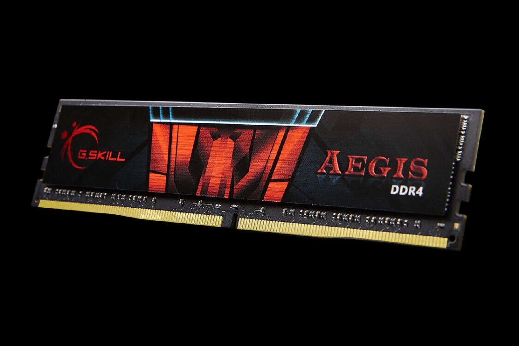 Moduł RAM G.Skill Aegis DDR4 z czarnym i pomarańczowym designem, na czarnym tle.