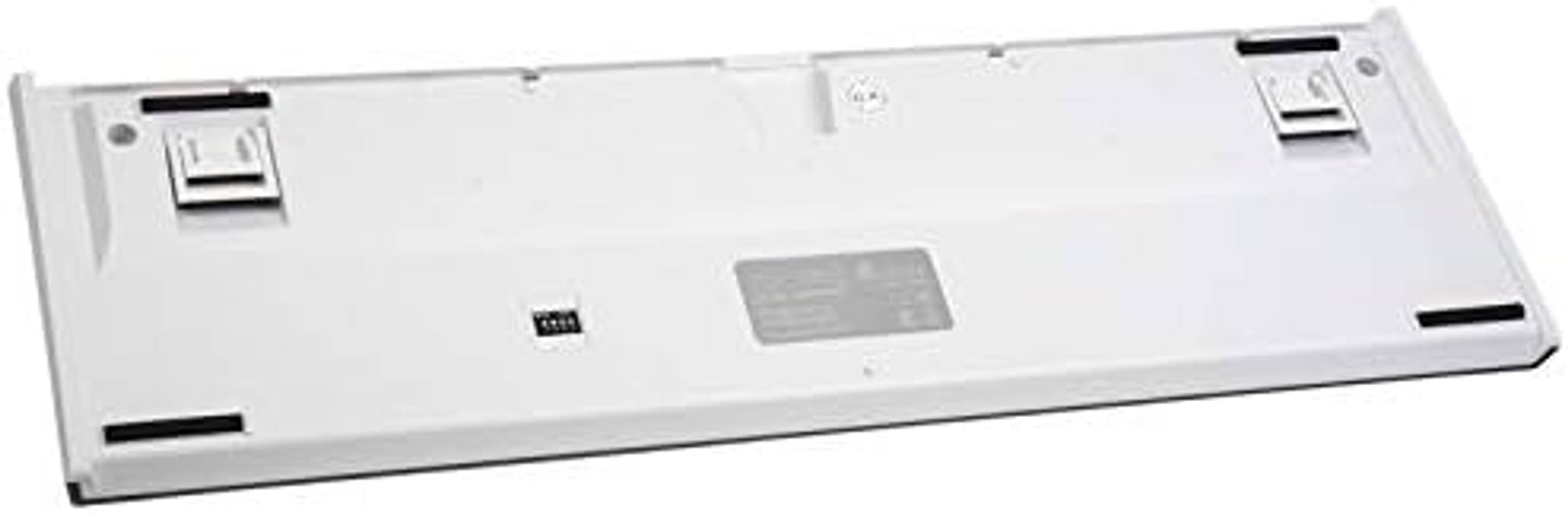 Baza białej klawiatury, z czarnymi gumowymi podkładkami i klipsami montażowymi.