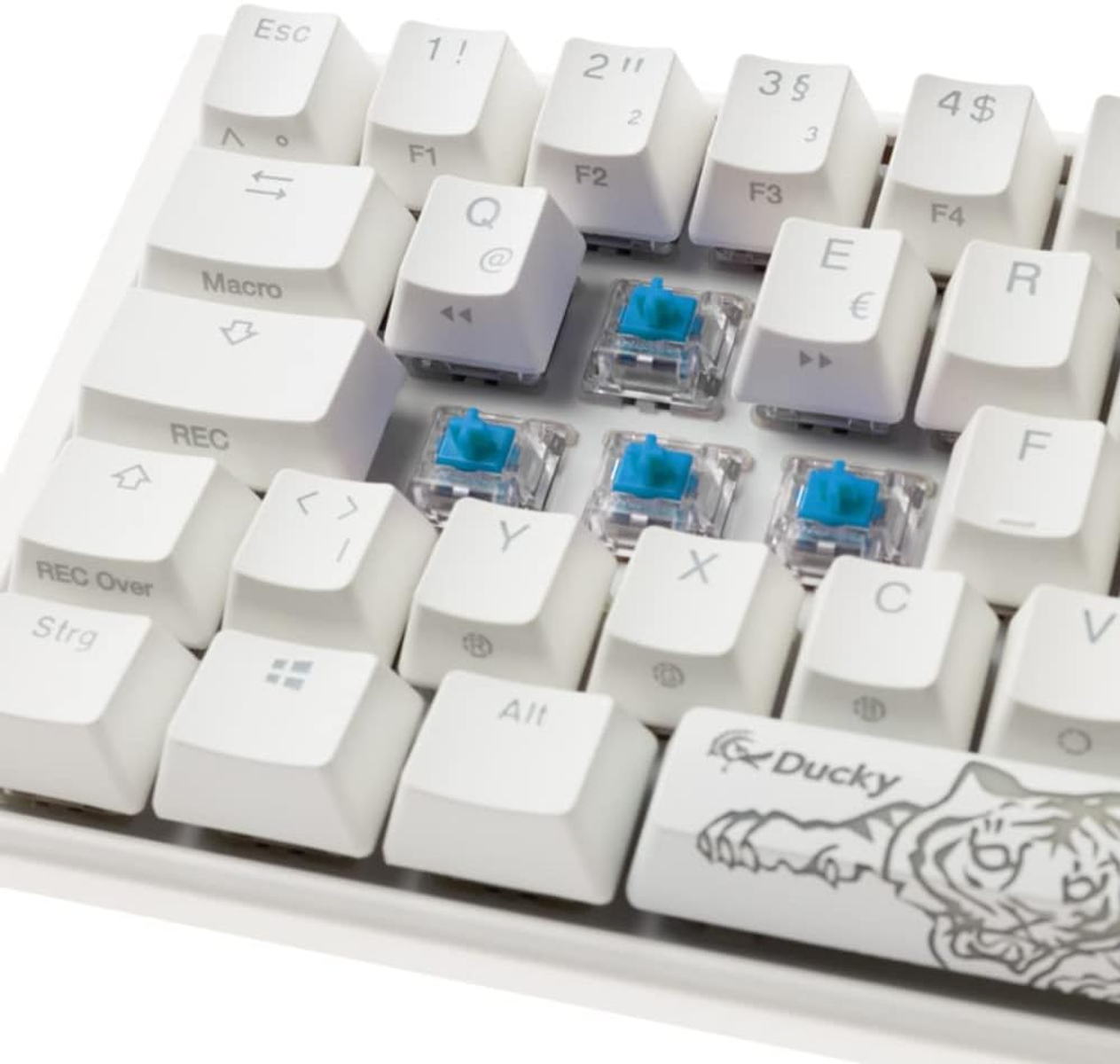 Primo piano di una tastiera con tasti bianchi e interruttori blu esposti. Alcuni tasti sono rimossi.