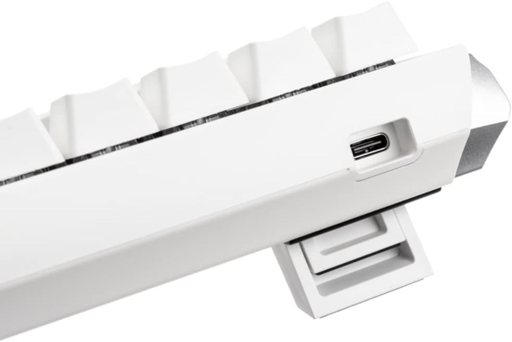 Tastiera bianca, vista laterale, con porta USB-C e supporto.