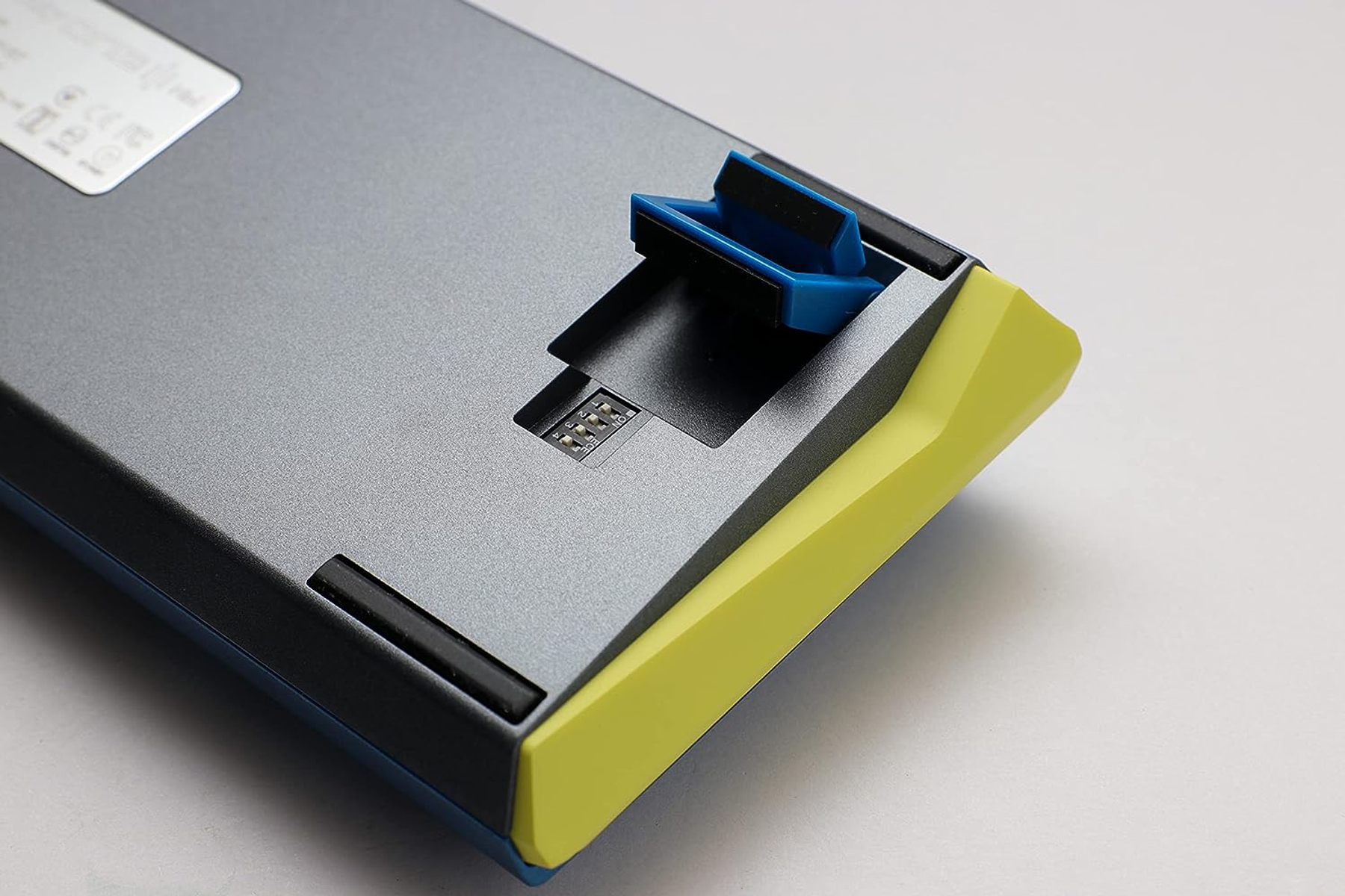 Lato inferiore di una tastiera. La combinazione di colori è composta da blu, giallo e grigio.