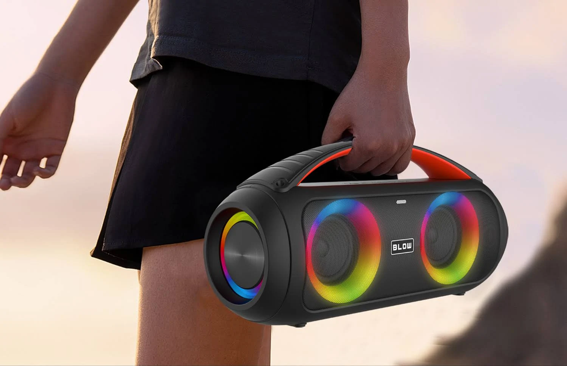 Schwarzer tragbarer Lautsprecher mit bunten LED-Lichtern, gehalten von einer Hand.