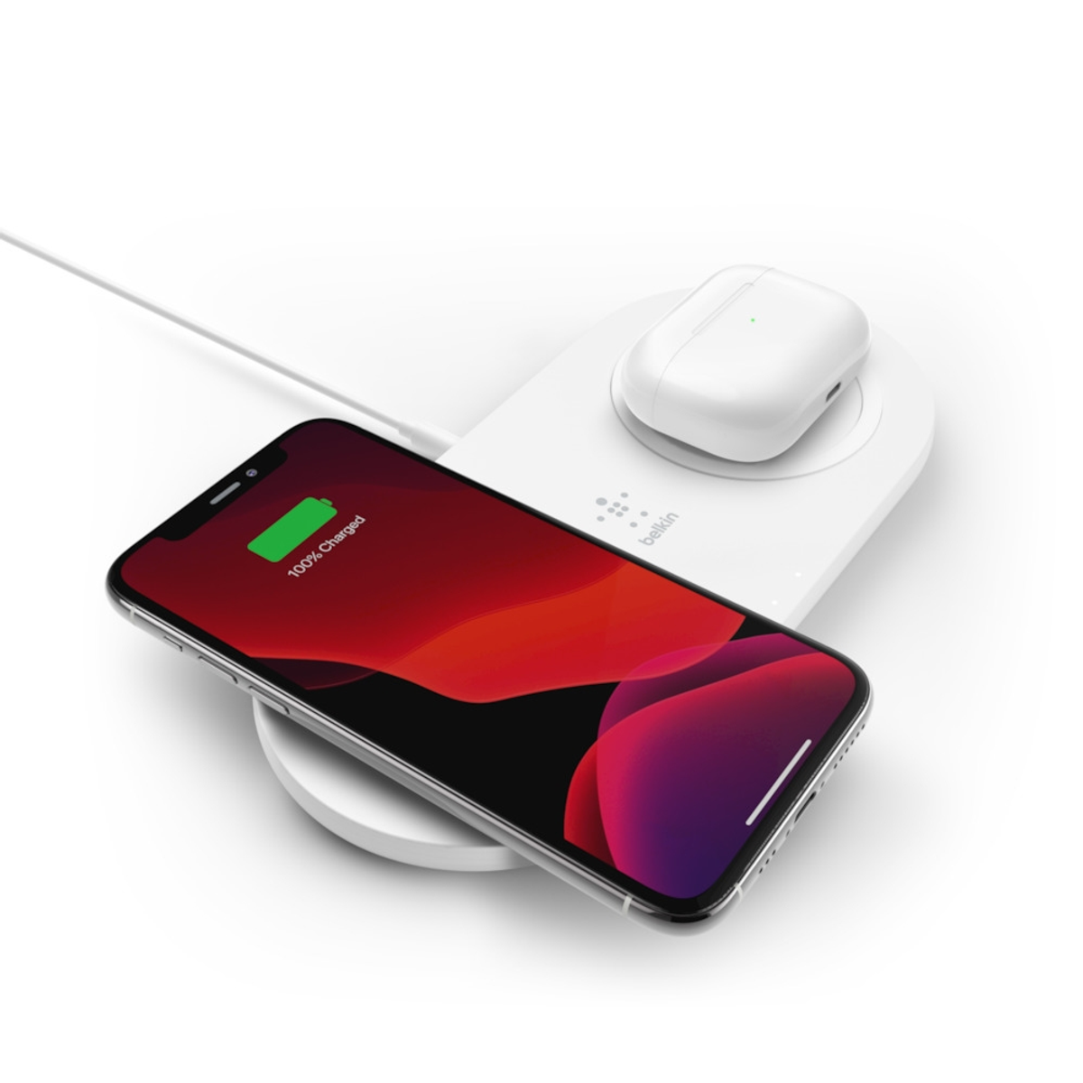 Weißes Ladepad mit Telefon und Ohrhörern. Telefon zeigt Aufladen. Weißer Hintergrund.