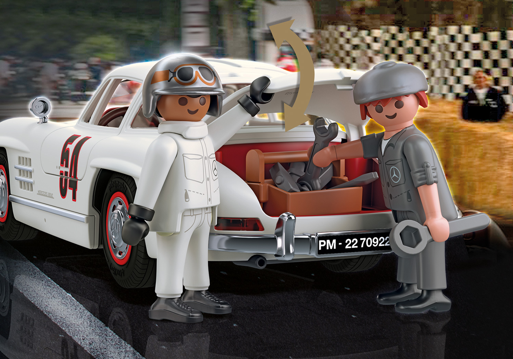 Due figure Playmobil vicino a un'auto d'epoca bianca. Una indica una cassetta degli attrezzi.
