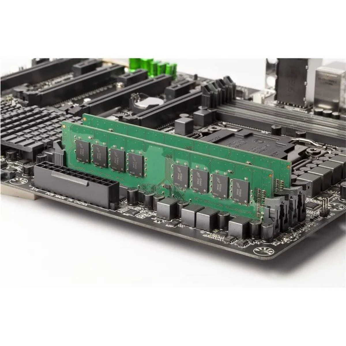 Grüne RAM-Riegel auf einem Motherboard mit verschiedenen Komponenten installiert.