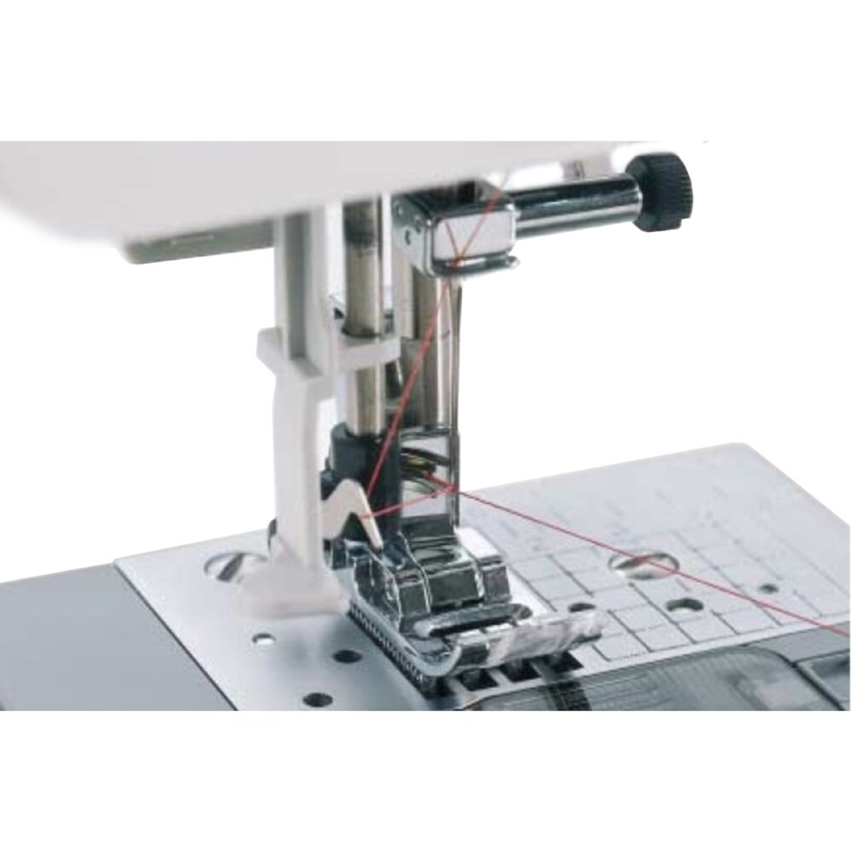 Zbliżenie igły i stopki maszyny do szycia. Widoczna czerwona nić. Białe tło.