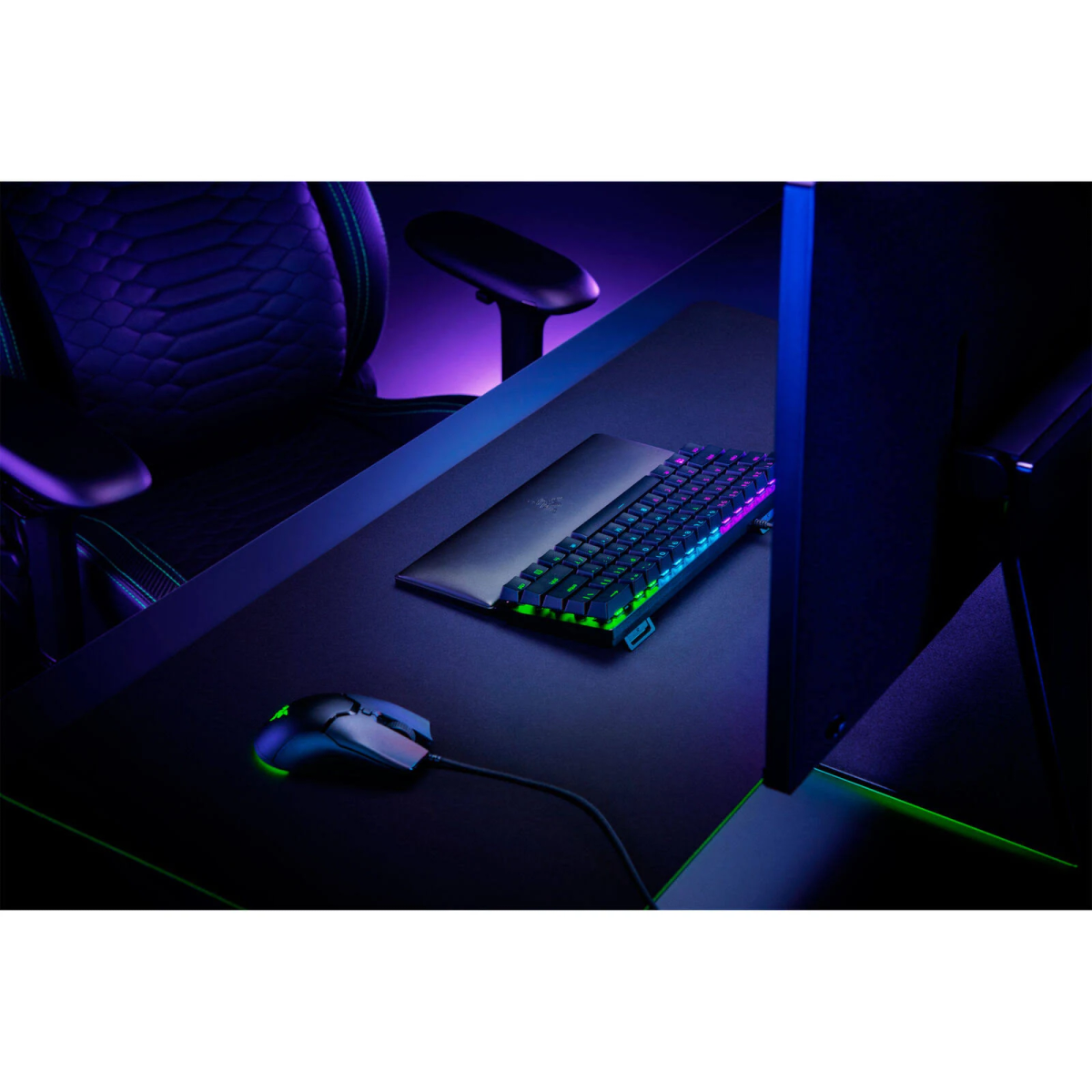 Gaming-Setup mit Tastatur, Maus und Stuhl. Die Szene ist dunkel mit blauen und grünen Lichtern.