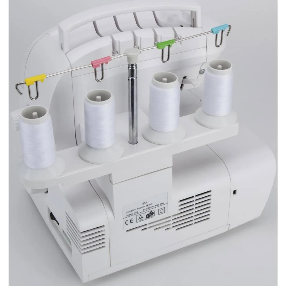 Biała maszyna do szycia owerlok z czterema szpulkami białej nici i kolorowymi prowadnicami nici.