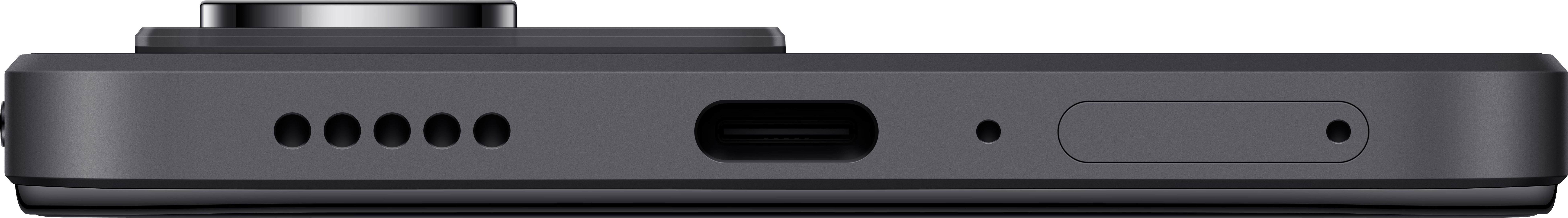 Primo piano della parte inferiore di un telefono grigio scuro. Ha una porta di ricarica, fori per altoparlanti e un microfono.