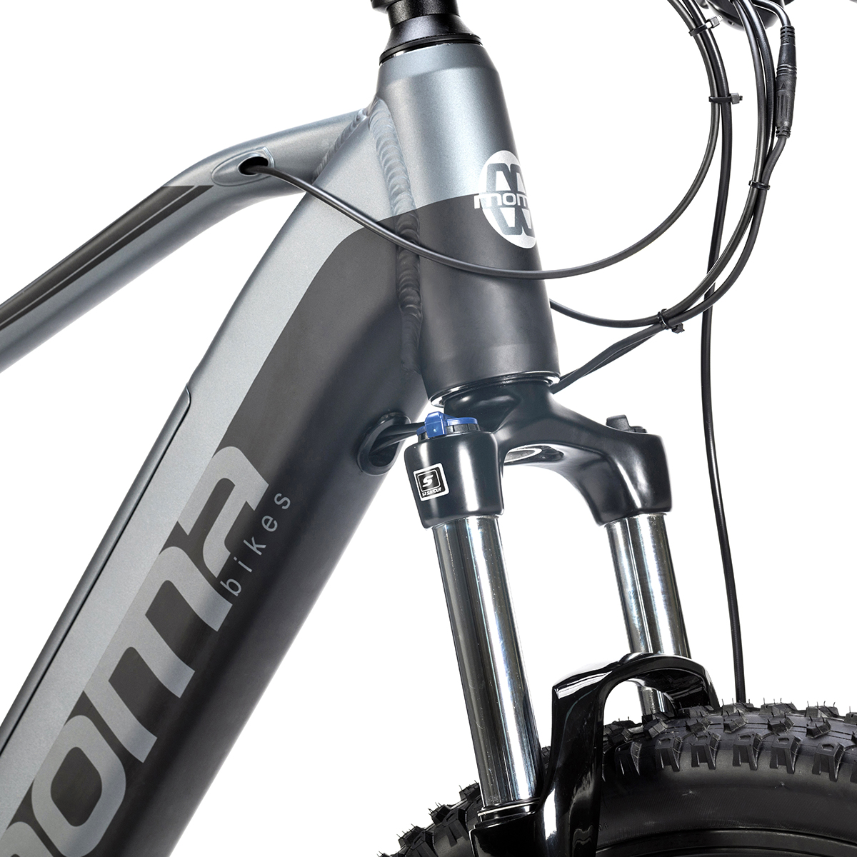 Nahaufnahme der Vorderseite eines grauen Elektrofahrrads. Der Markenname lautet "NOMA bikes".