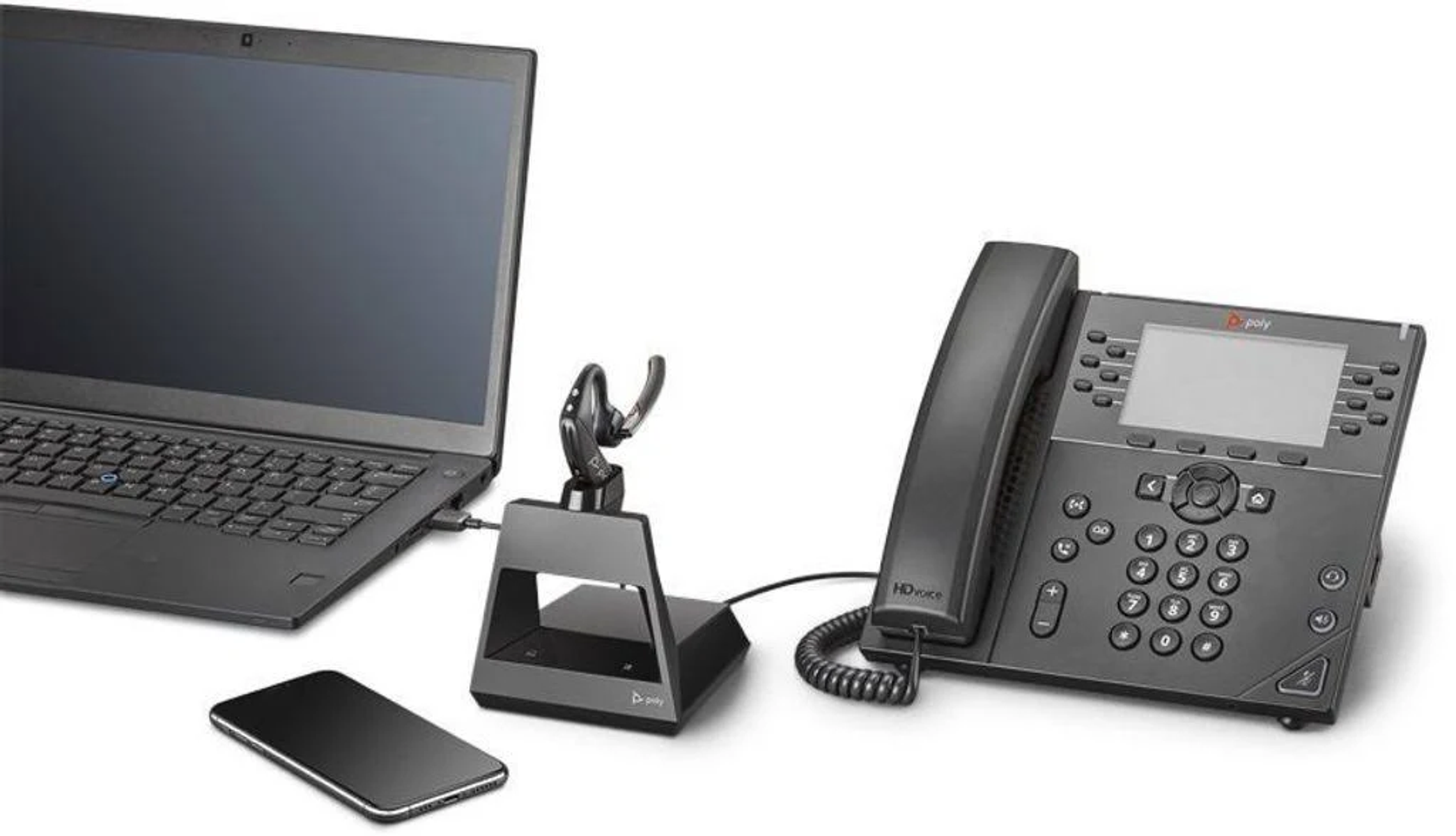 Laptop, zestaw słuchawkowy, telefon i telefon stacjonarny podłączone.