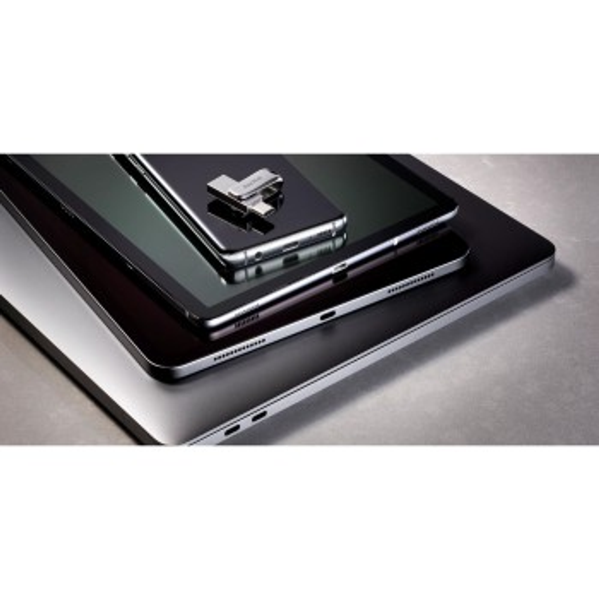 Trzy urządzenia elektroniczne ułożone: laptop, tablet i smartfon.