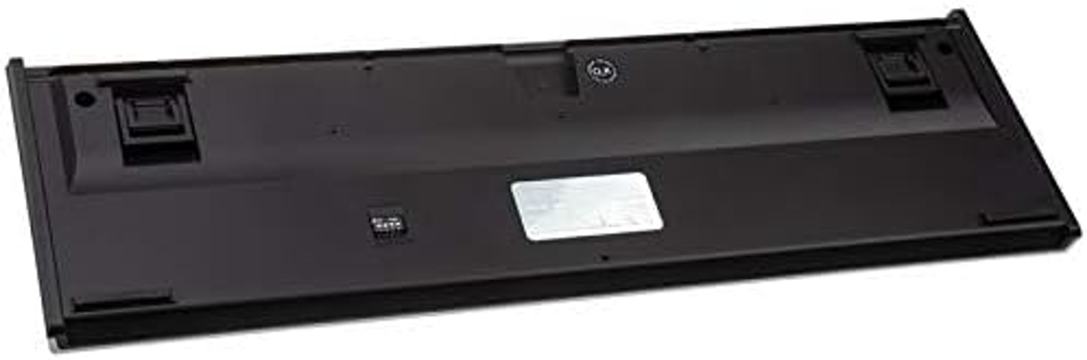 Spód czarnej klawiatury z gumowymi nóżkami i etykietą.