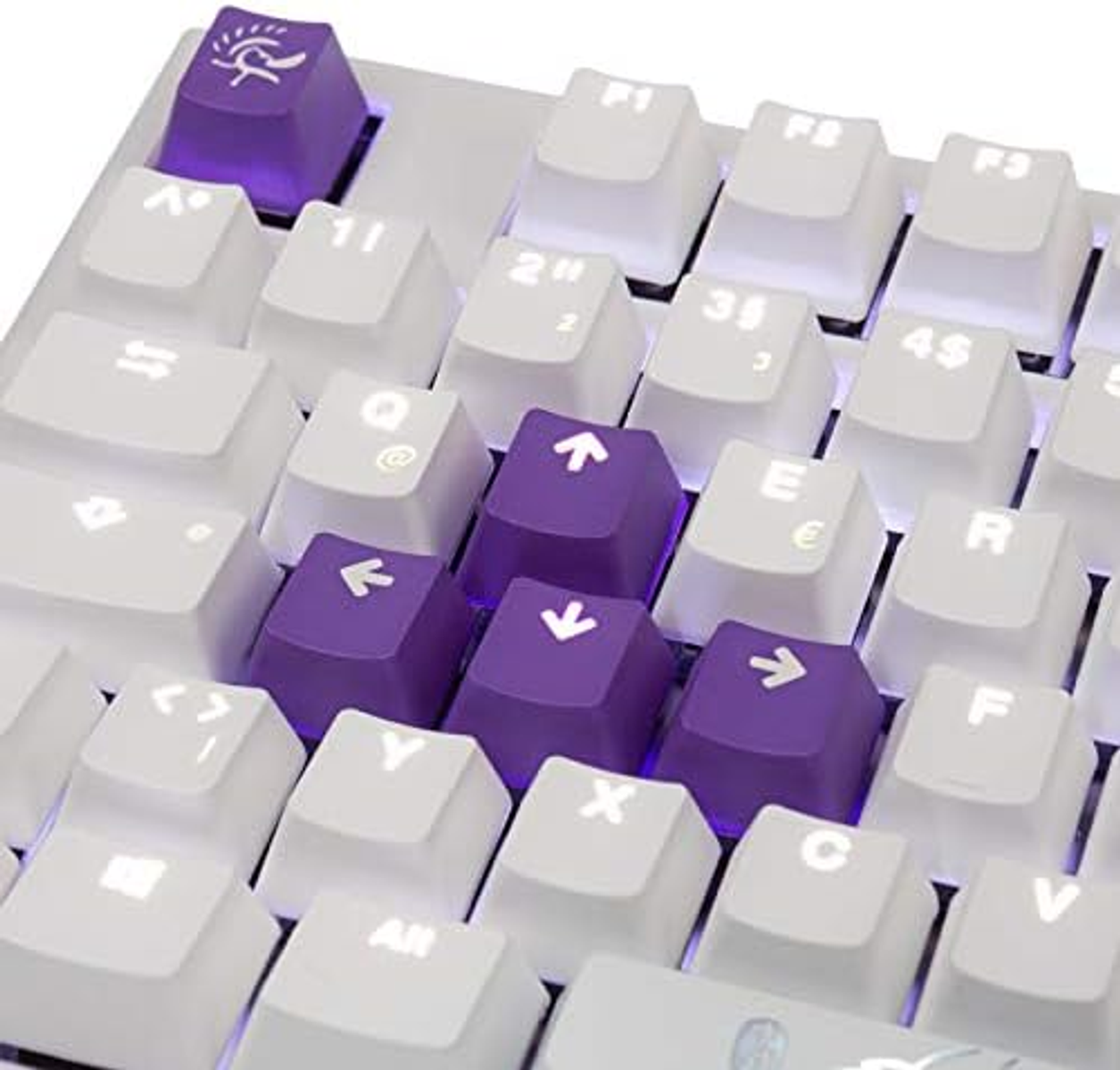 Biała klawiatura z fioletowymi klawiszami strzałek i jednym fioletowym klawiszem ze wzorem. Klawisze są białe.