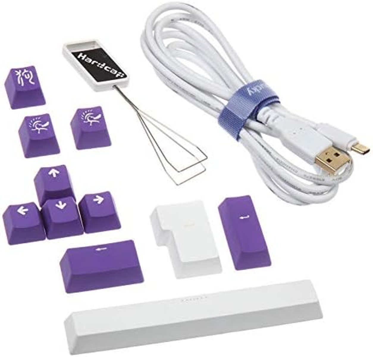 Zestaw klawiszy klawiatury z fioletowymi i białymi klawiszami, ściągaczem klawiszy i kablem USB.