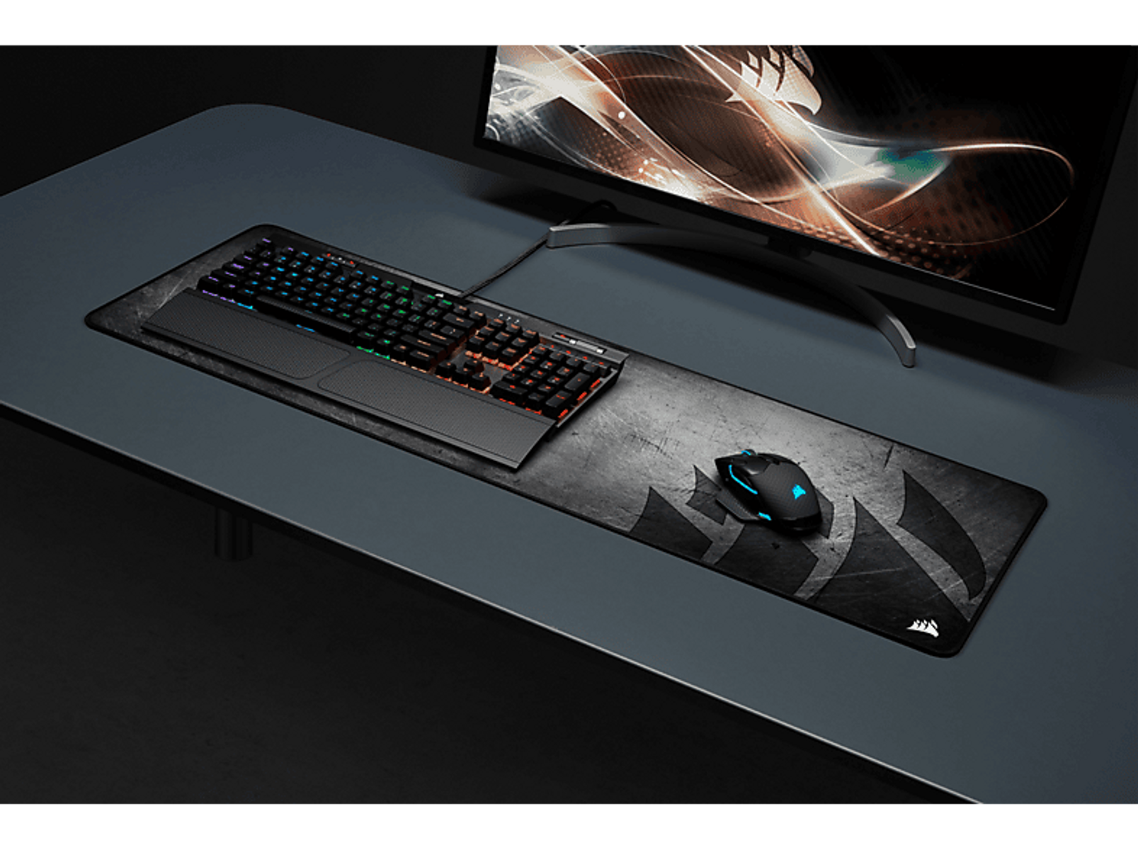 Konfiguracja biurka z klawiaturą, myszą i podkładką. Ciemne tło.