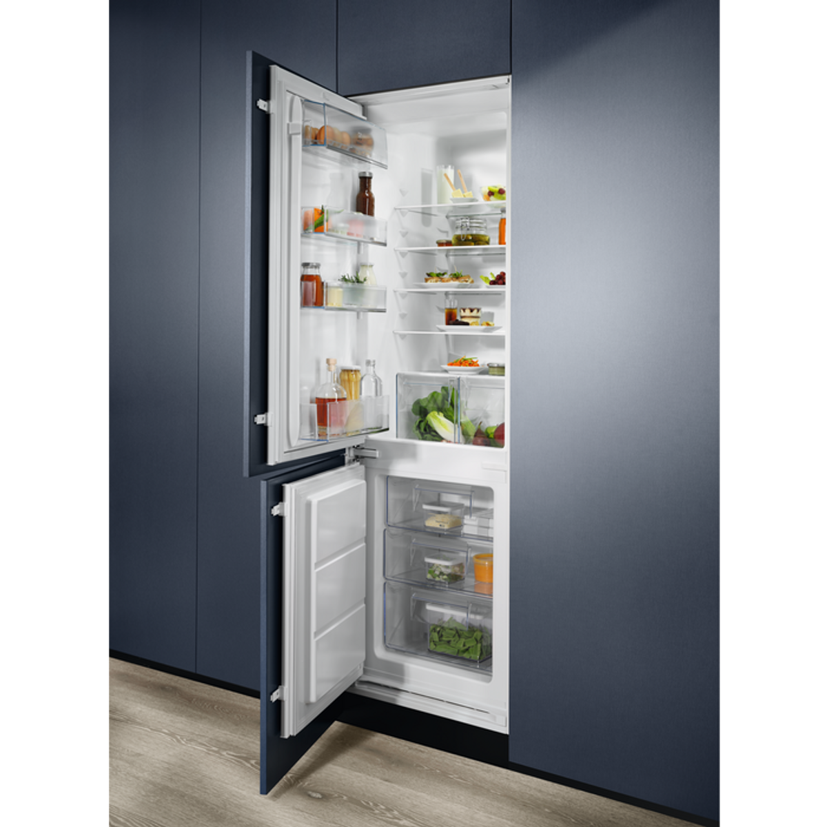 Refrigerador abierto con contenido. Estantes con alimentos. Armarios azules al fondo.