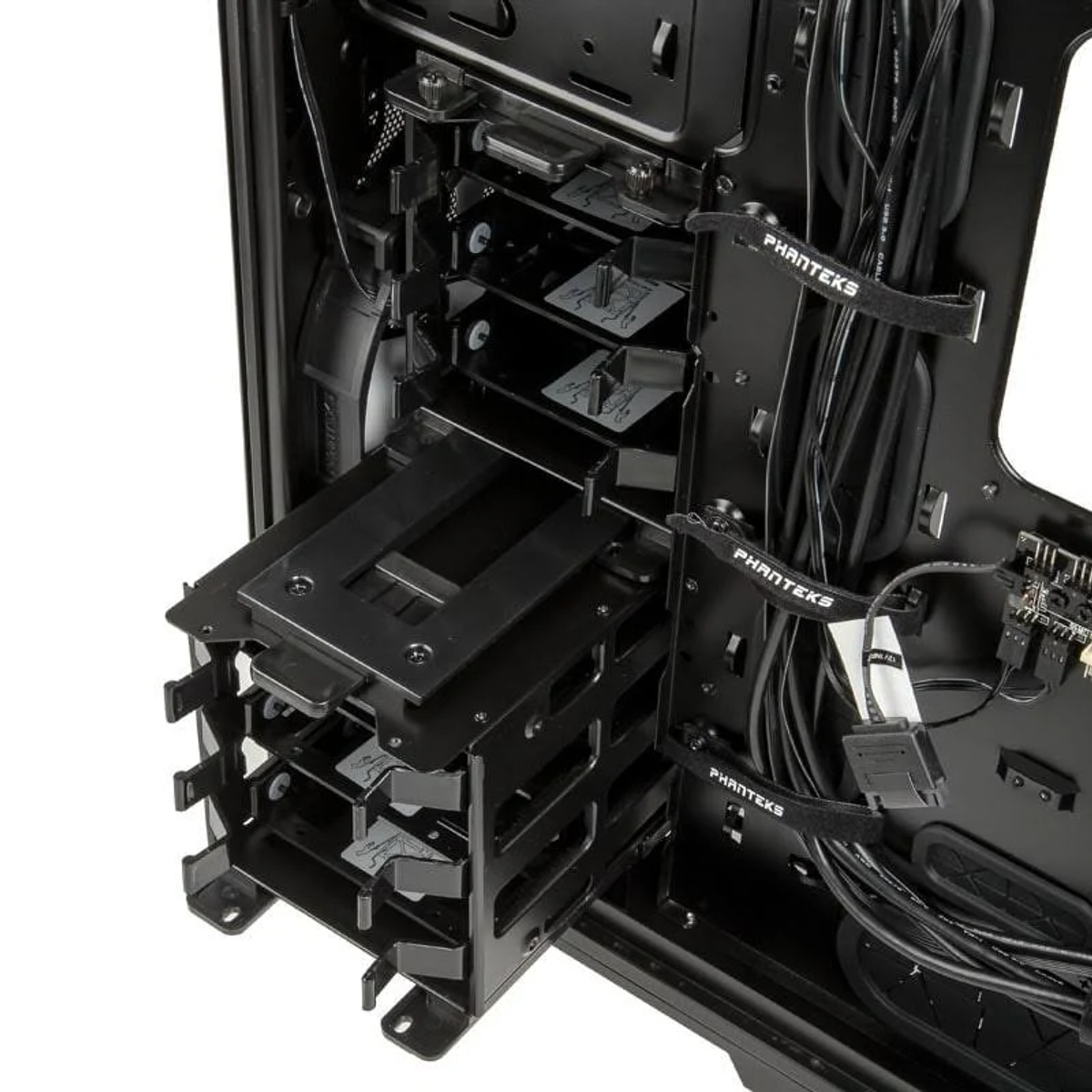 Interieur van een zwarte pc-behuizing. Toont de HDD-kooi, kabels en montagehardware.