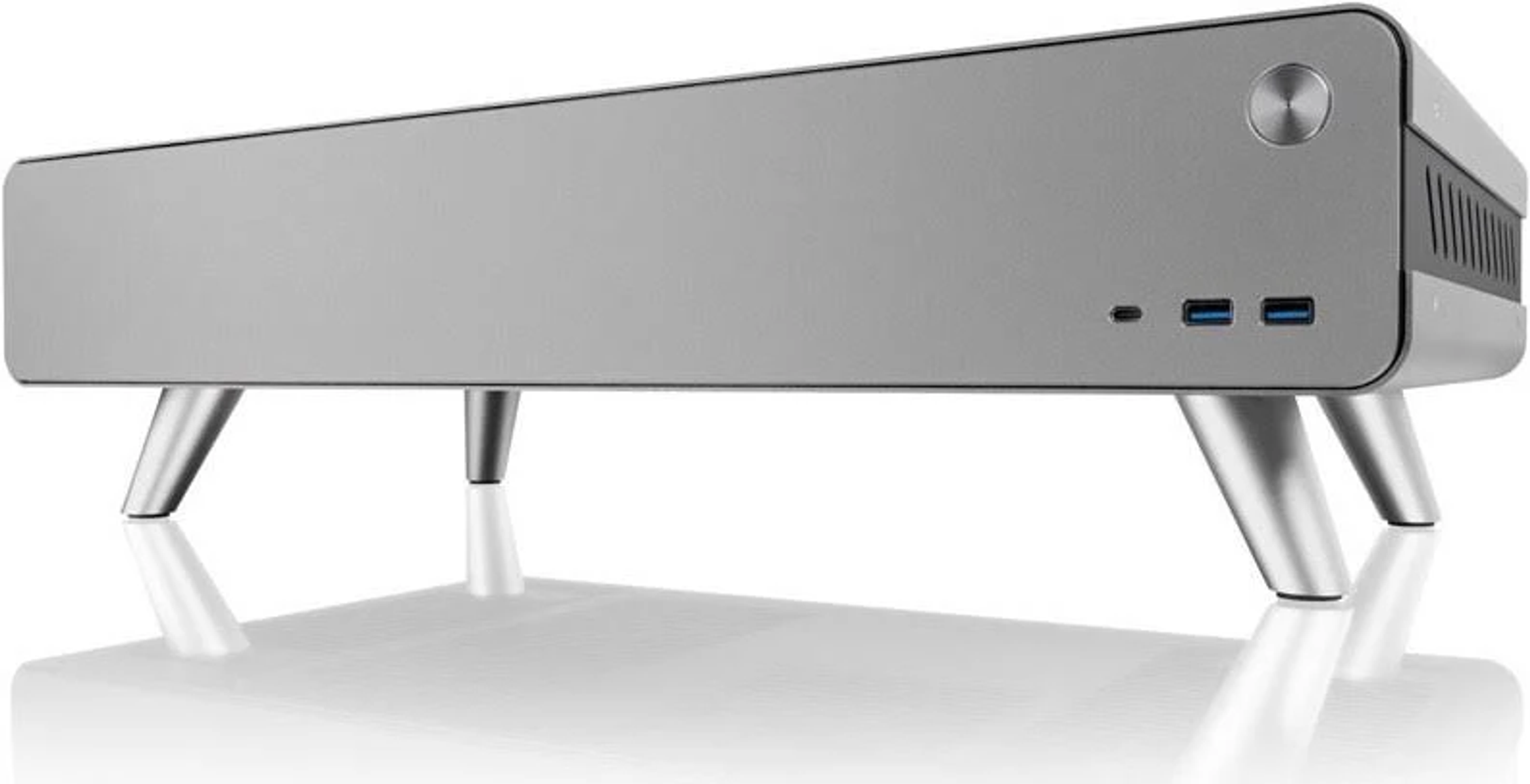 Silbernes Computergehäuse mit Beinen. Es hat einen Power-Knopf, USB-Anschlüsse und einen Lüfter hinten.
