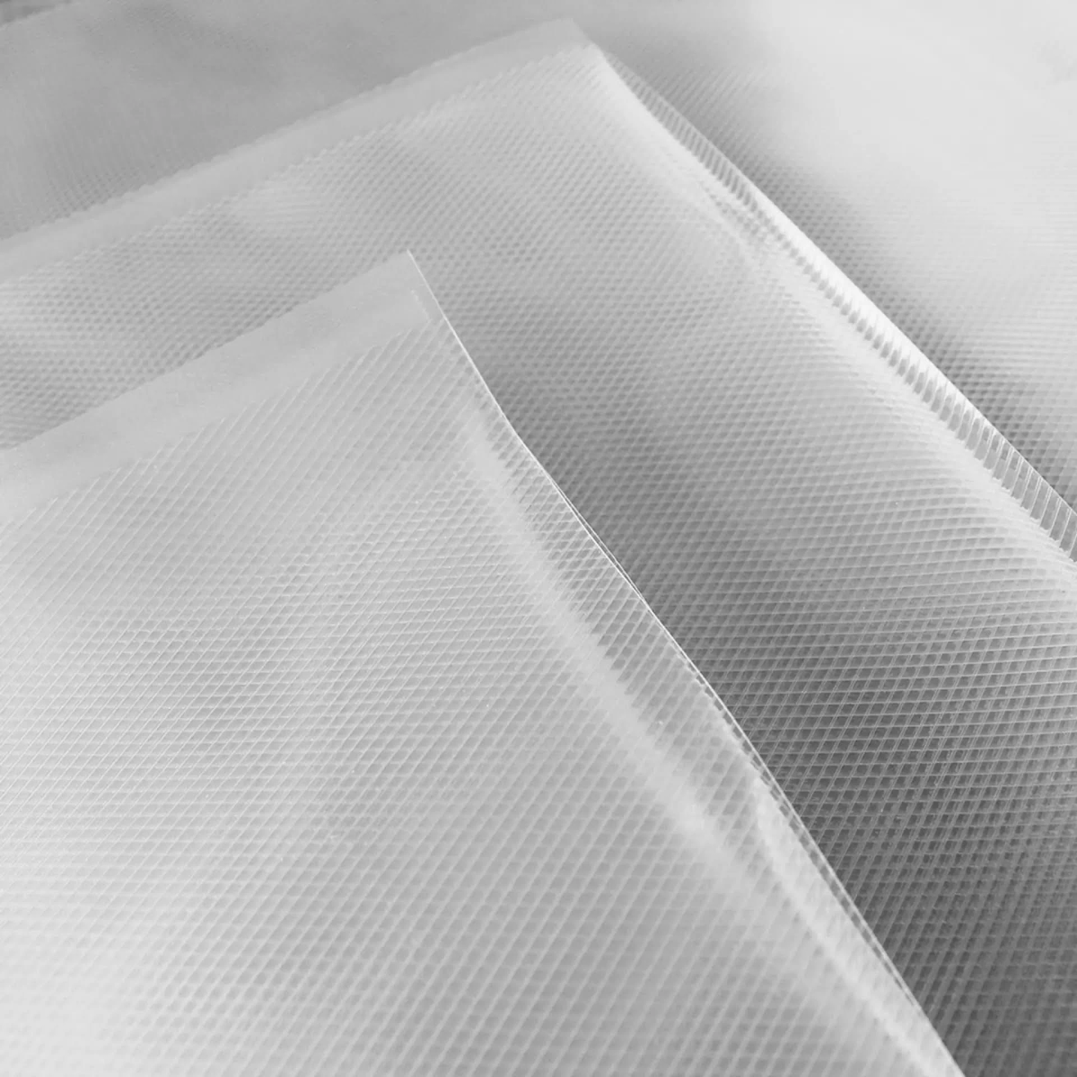 Drei transparente Dokumententaschen auf hellgrauer Oberfläche. Nahaufnahme.