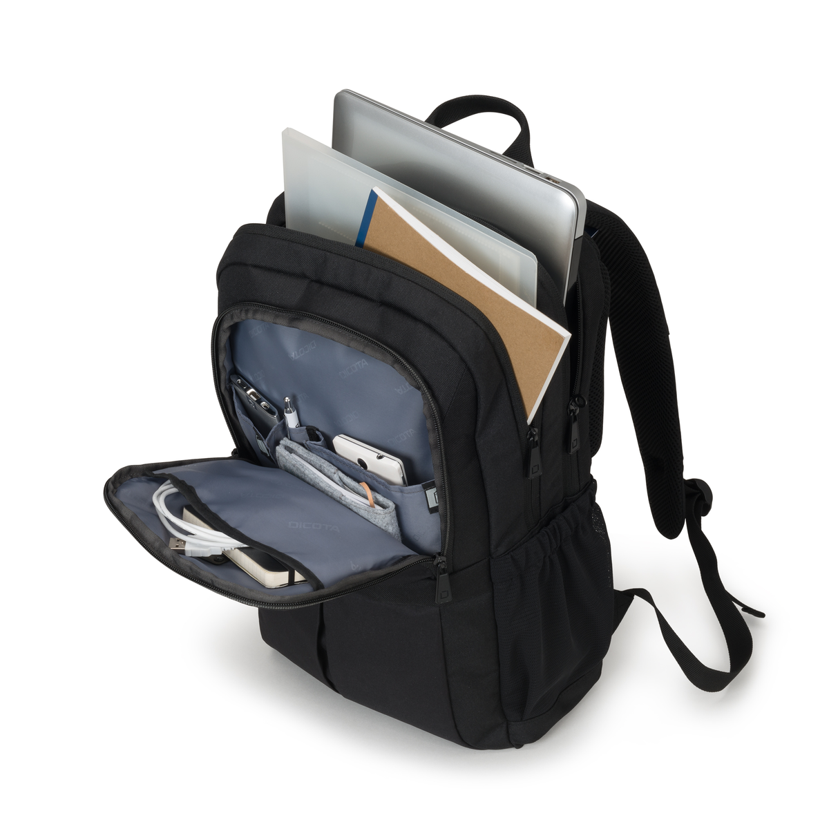 Sac à dos noir avec poches ouvertes montrant ordinateur portable, cahier et accessoires. Blanc.