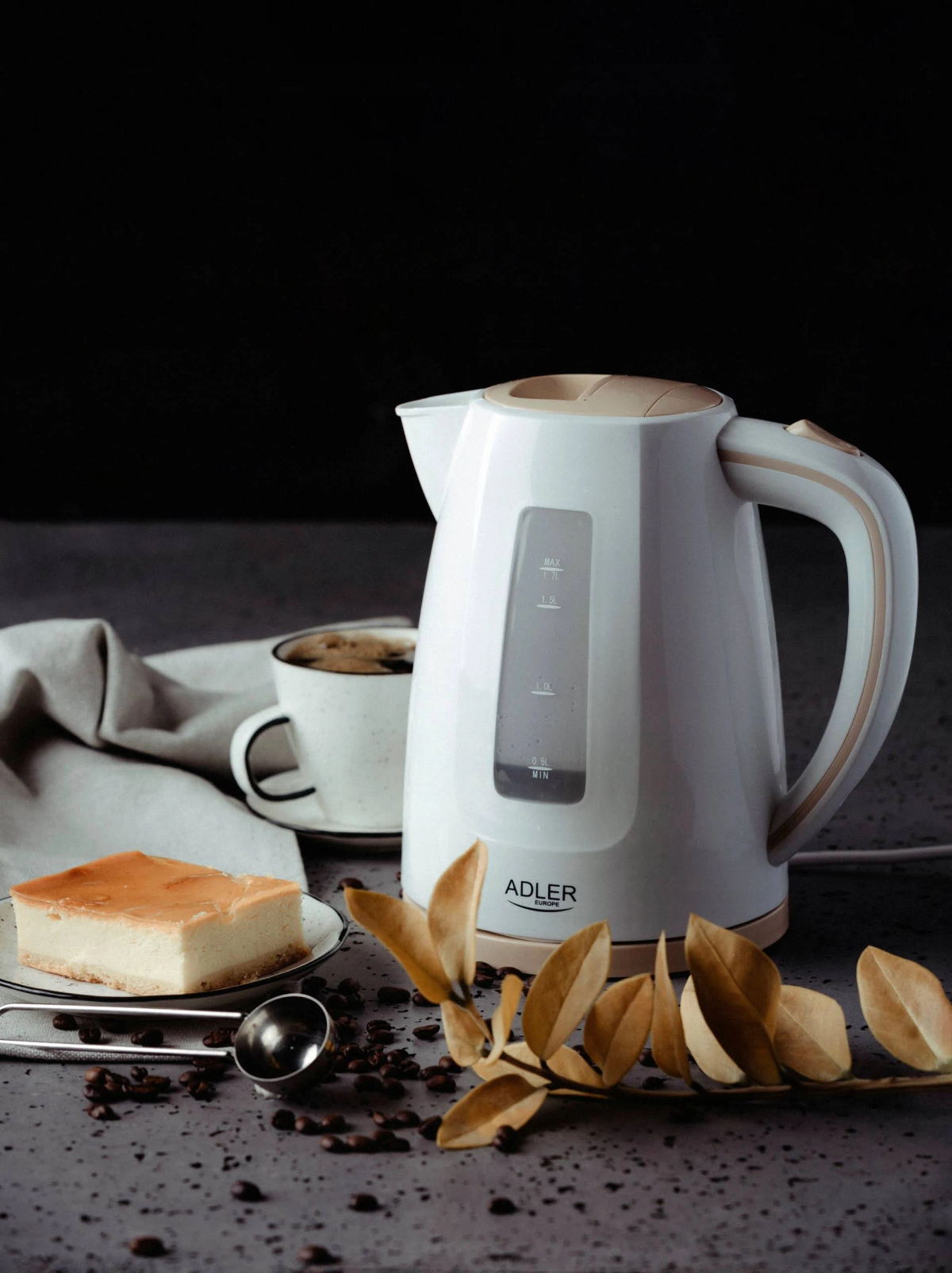 Bouilloire électrique blanche avec café, gâteau et grains de café.