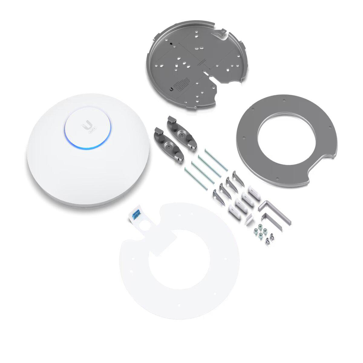 Białe komponenty urządzenia sieciowego Ubiquiti są ułożone na białej powierzchni, różne elementy montażowe.