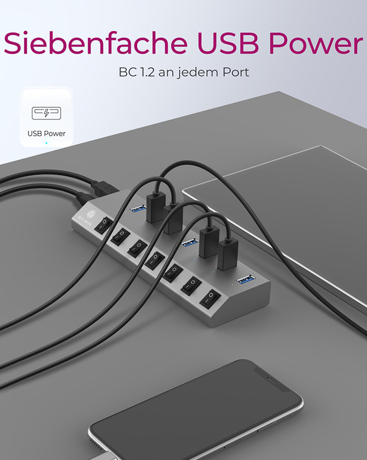 Ein silberner USB-Hub mit mehreren Anschlüssen. Der Hub hat mehrere Schalter und ist mit einem Smartphone und Tablet verbunden.