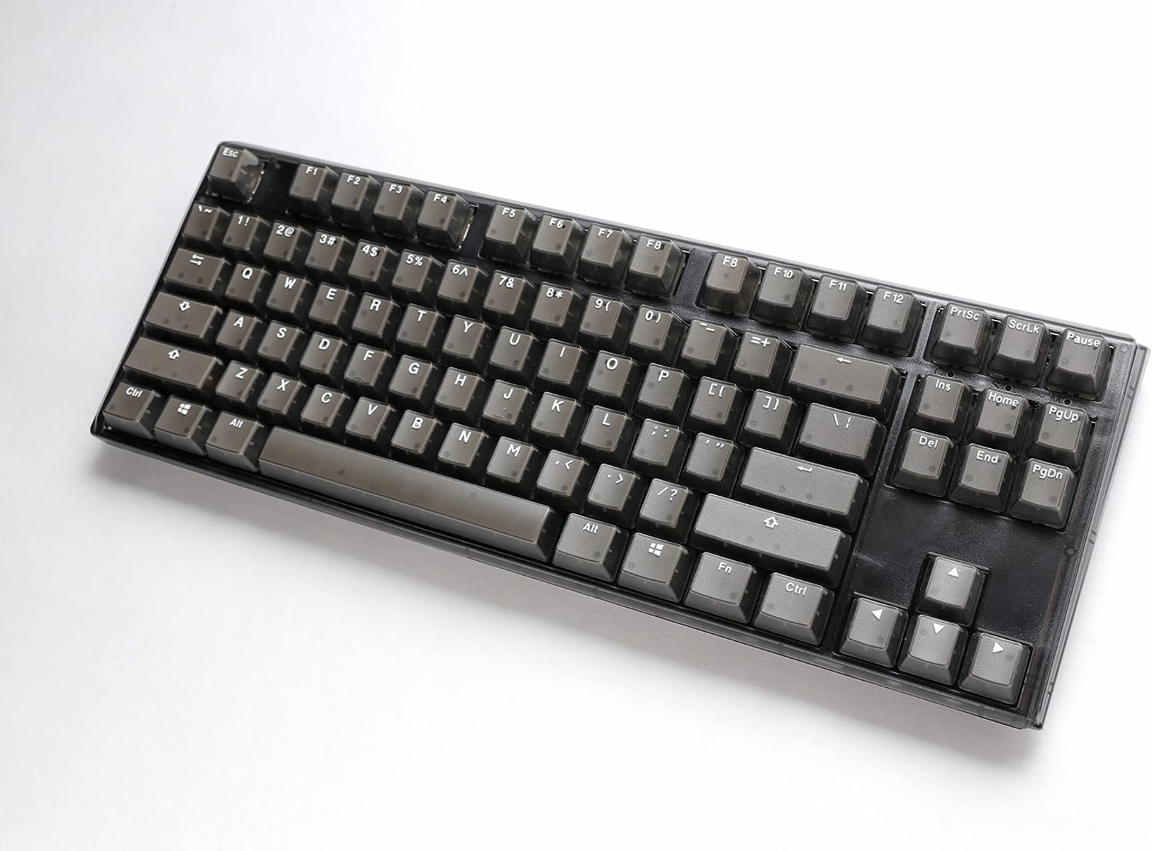 Donkergrijs toetsenbord, standaard lay-out, met donkergrijze keycaps en witte achtergrond.