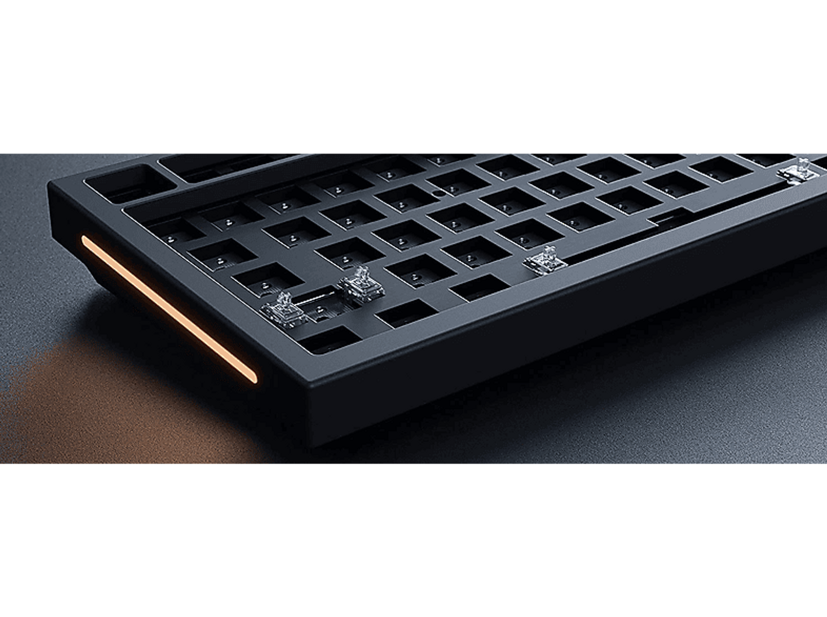 Schwarze mechanische Tastatur mit orangem Lichtstreifen. Tasten sind sichtbar, die Basis ist dunkel.