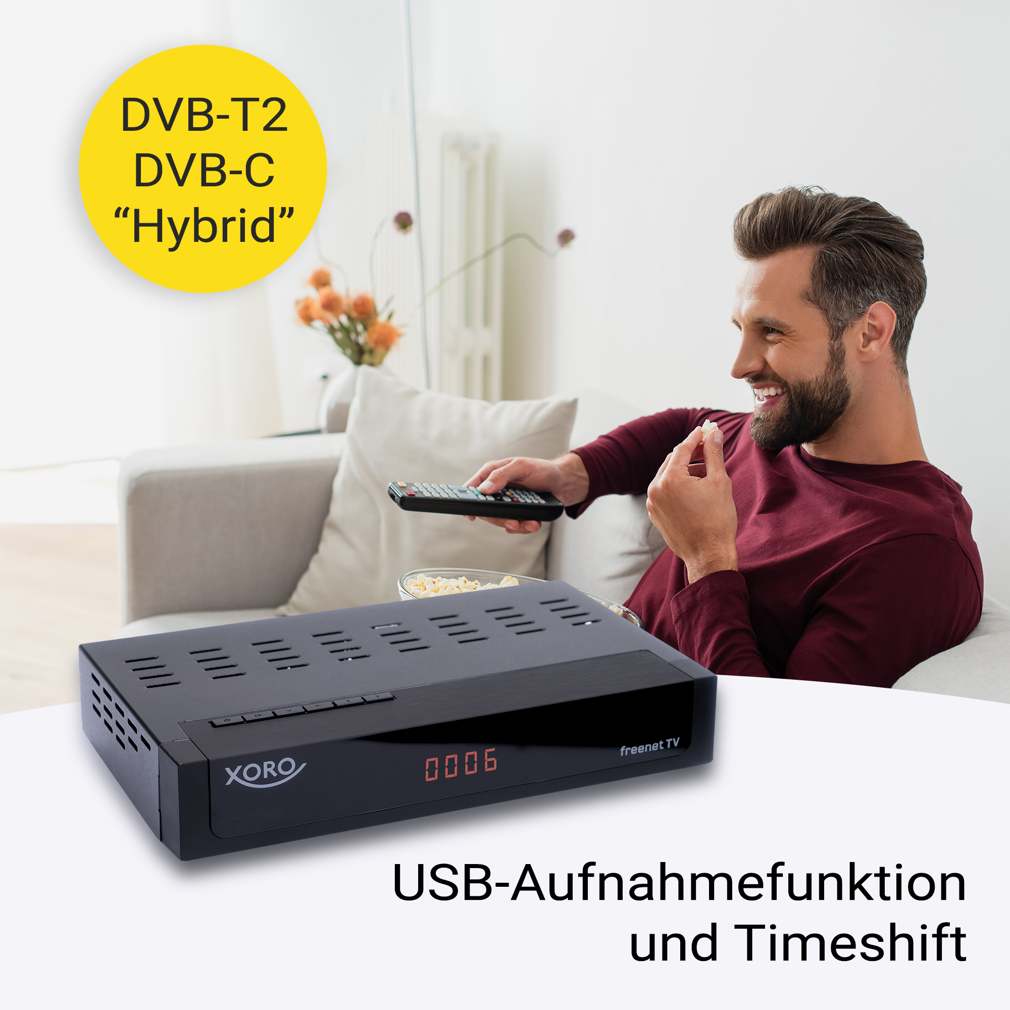 Mann hält Fernbedienung, schaut TV. Schwarzer Receiver und Text auf dem Bildschirm.