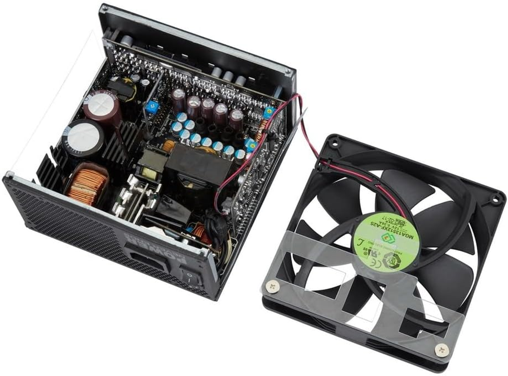 Un alimentatore per computer aperto che mostra i componenti interni e una ventola staccata.