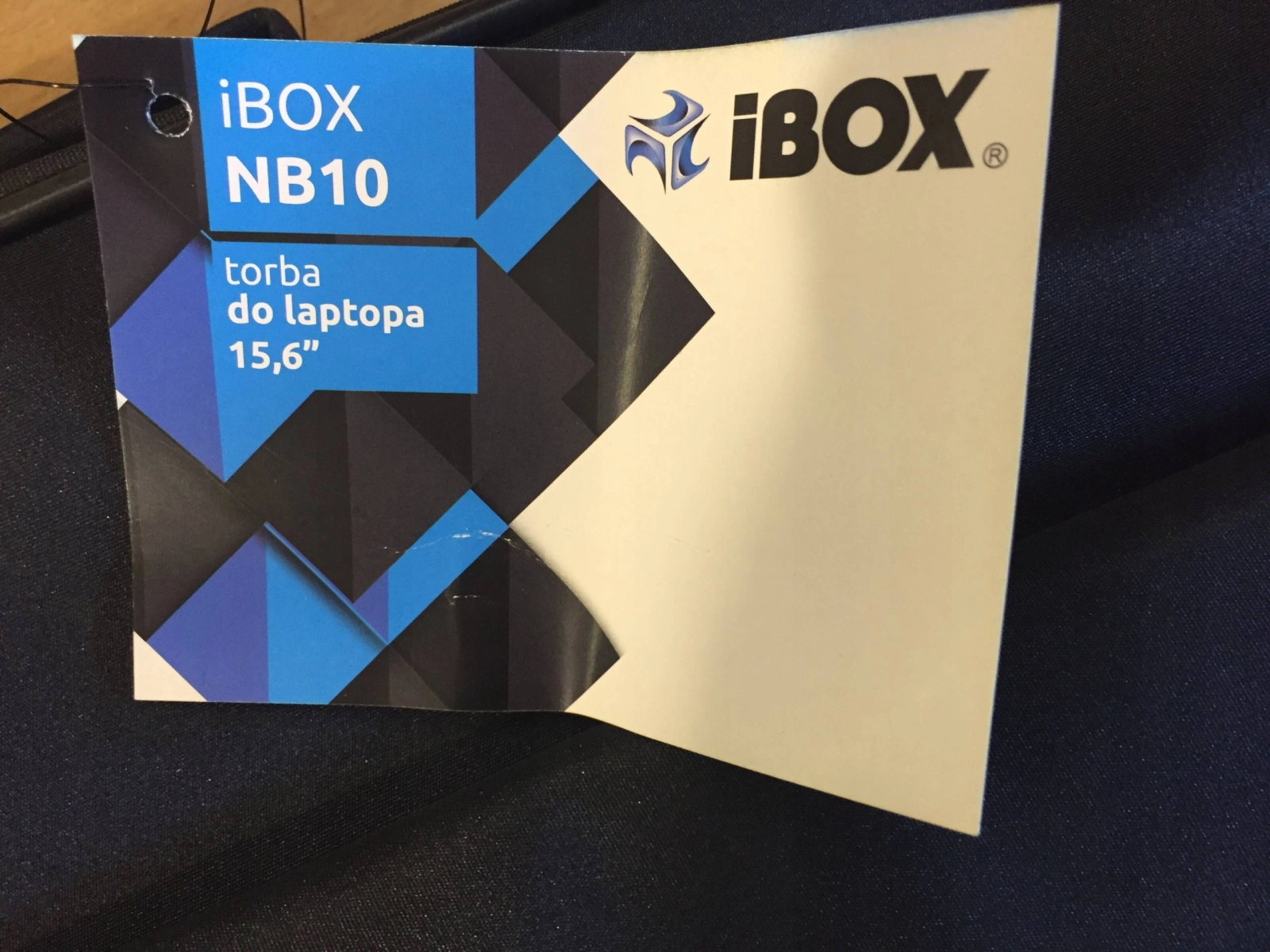 Un'etichetta per borsa per laptop iBOX NB10 bianca con design blu e nero, testo 15,6".