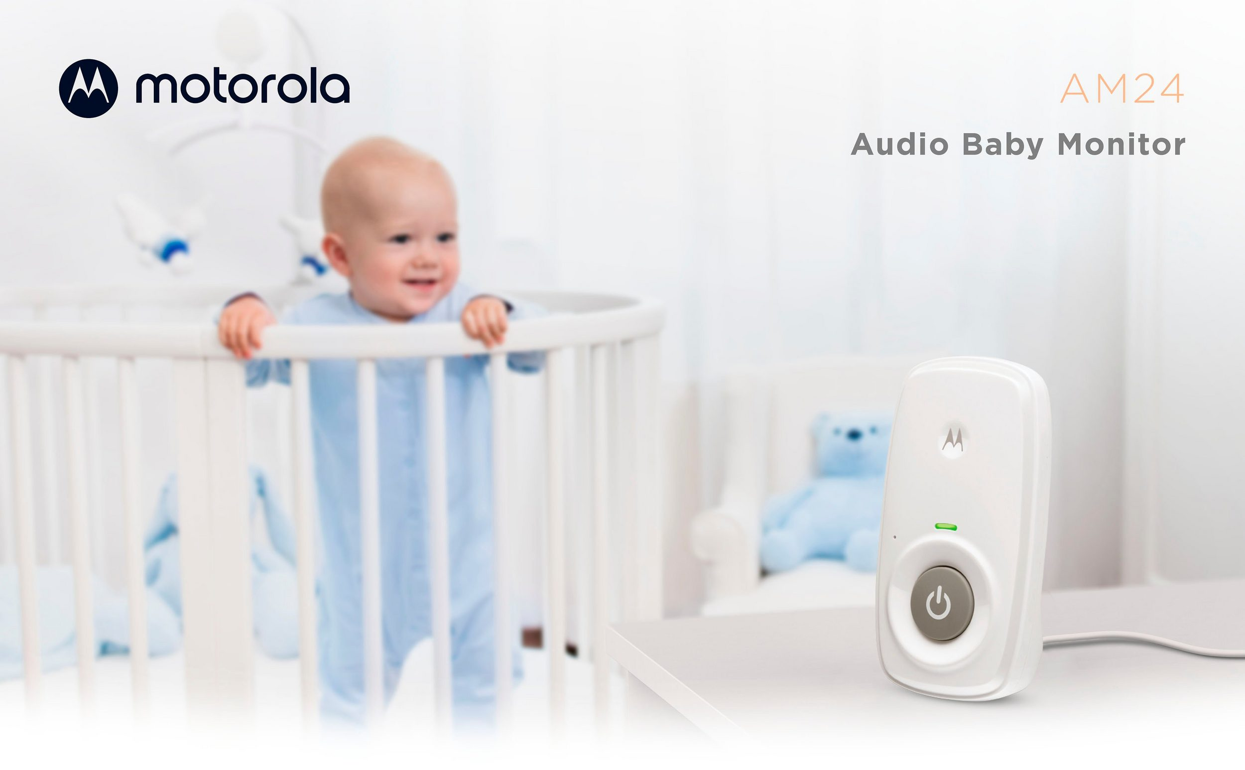 Babyphone auf einem Tisch mit einem Baby im Hintergrund. Modell Motorola AM24.