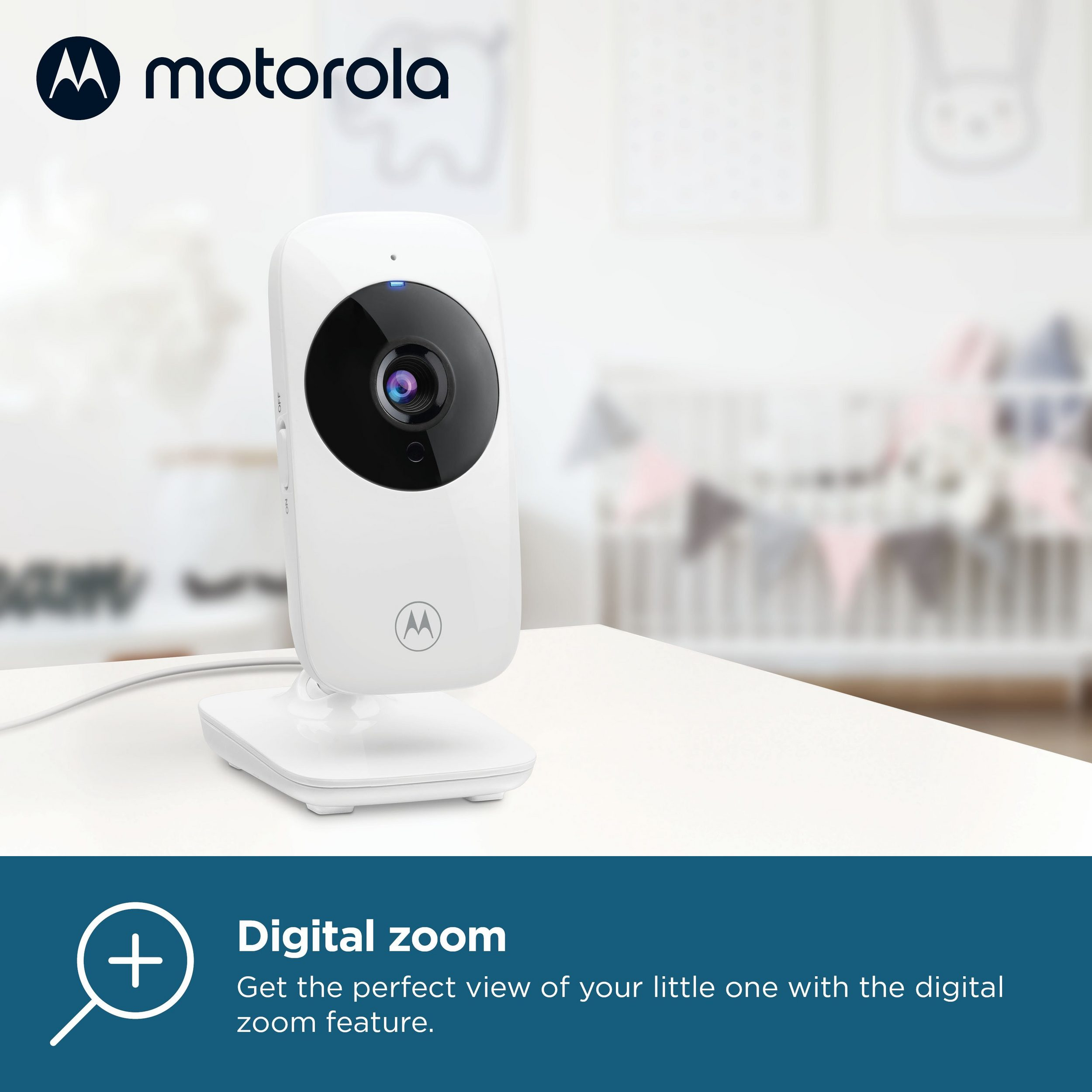 Baby monitor Motorola bianco. È posizionato su una superficie bianca. Lo sfondo è sfocato.