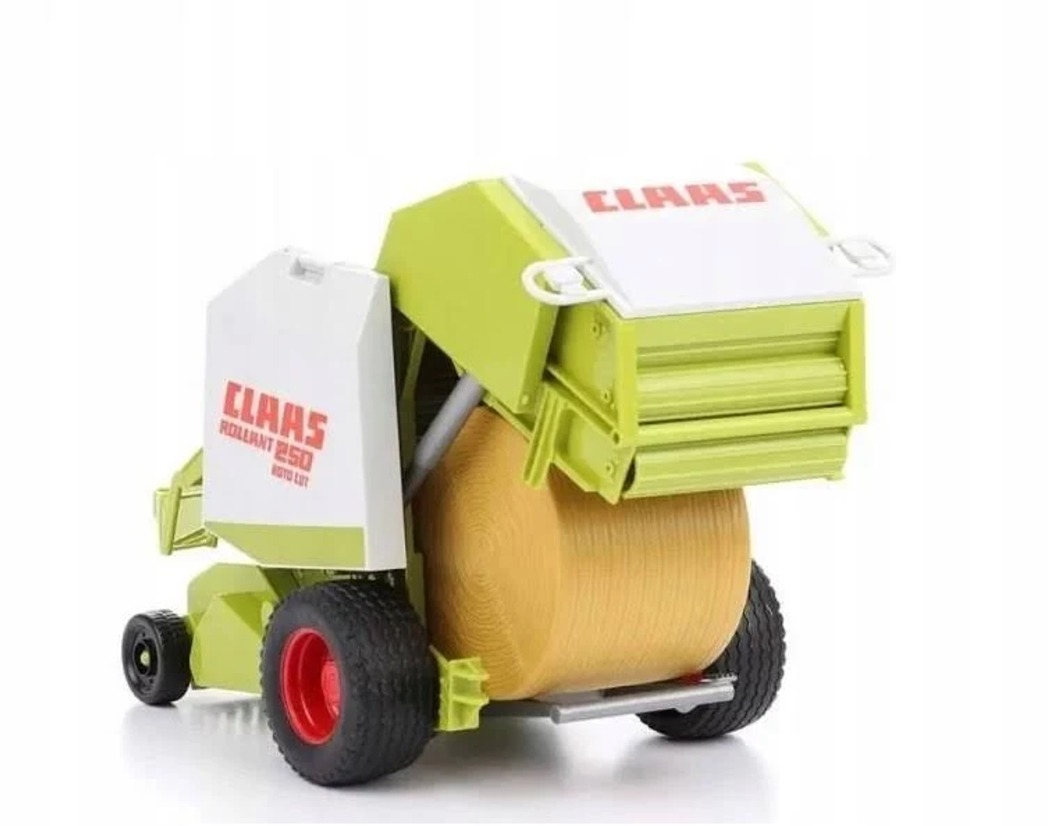 Zabawkowa prasa CLAAS z dużą belą siana w środku. Maszyna jest zielona i biała.