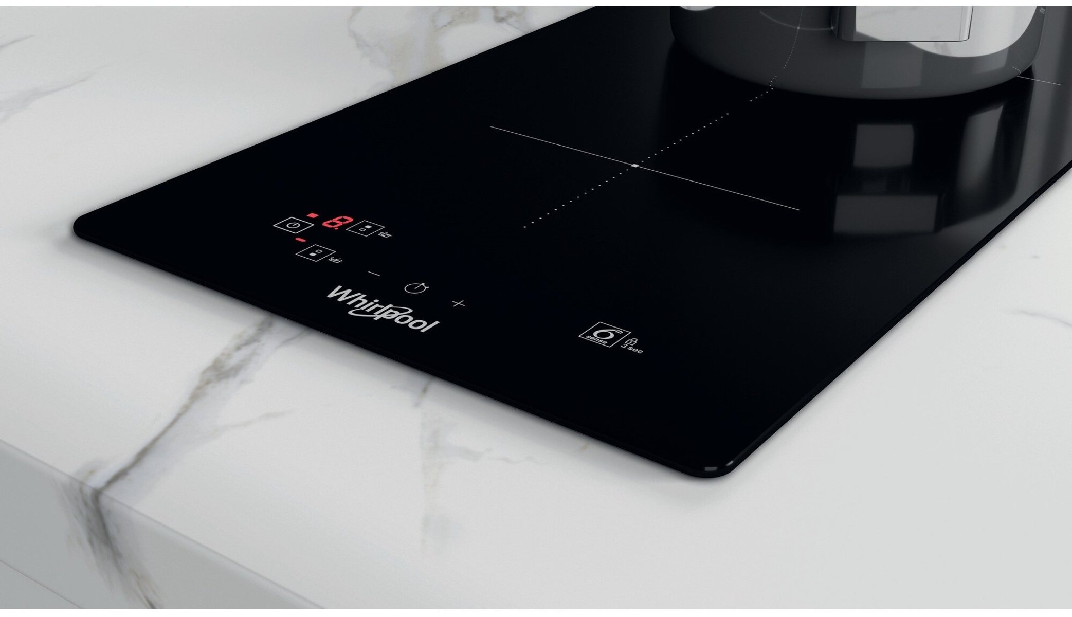 Zwarte Whirlpool inductiekookplaat met aanraakbediening. Een pan staat op het kookoppervlak. Marmeren aanrecht.