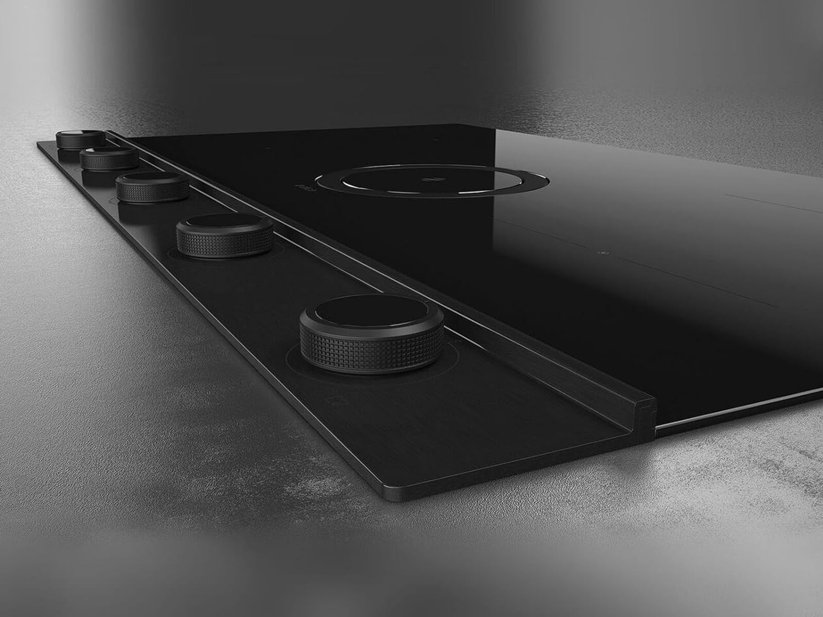 Piano cottura nero con pannello comandi. I comandi sono circolari.