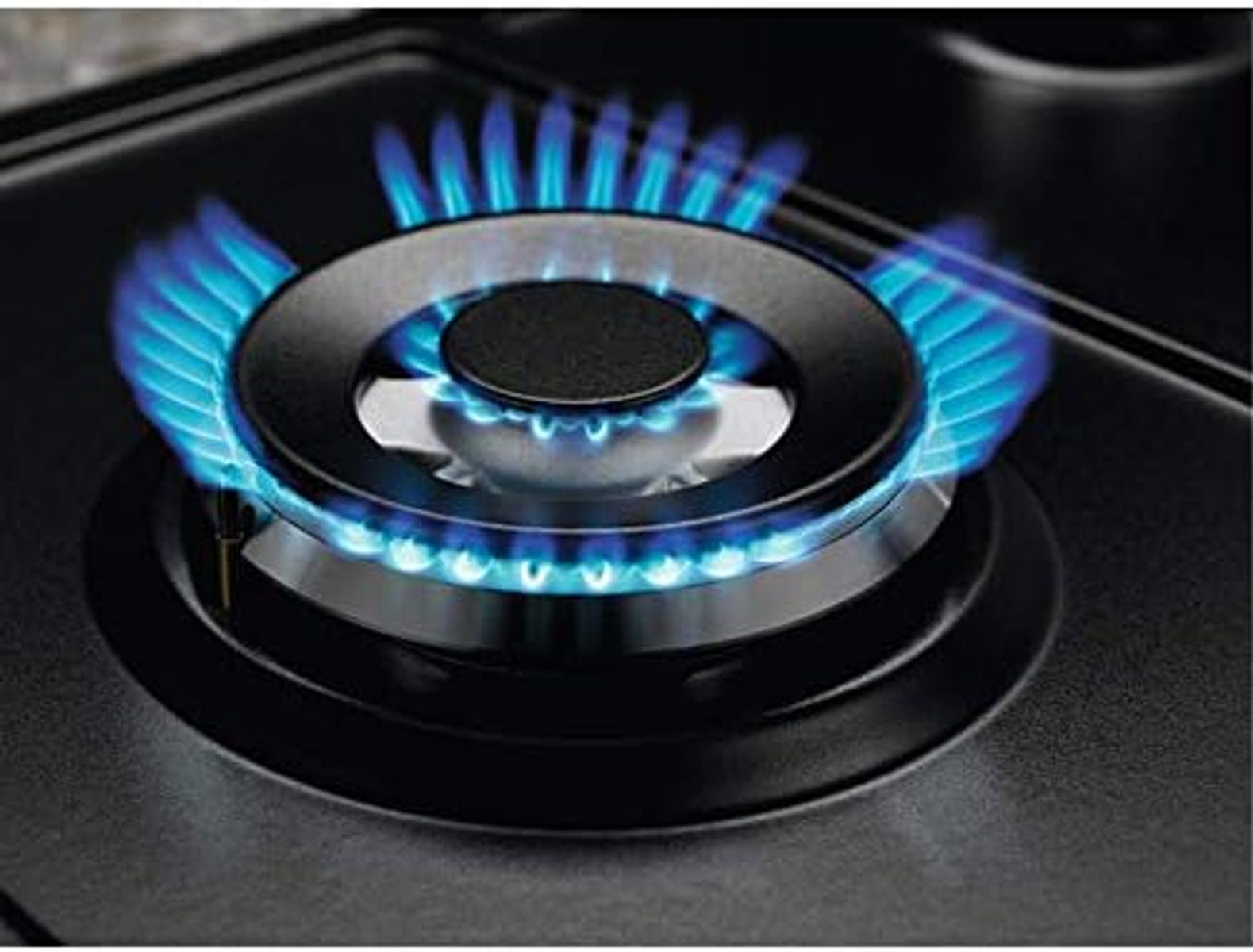 Zbliżenie palnika gazowego z niebieskimi płomieniami wydobywającymi się z czarnego palnika.