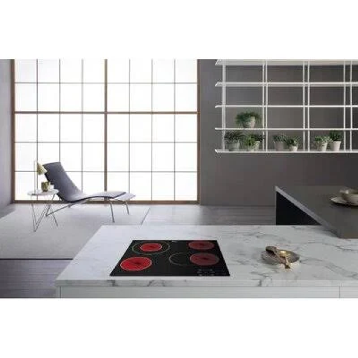 Cucina con isola bianca e piano cottura nero. Visibili anche una sedia, una finestra e una mensola.