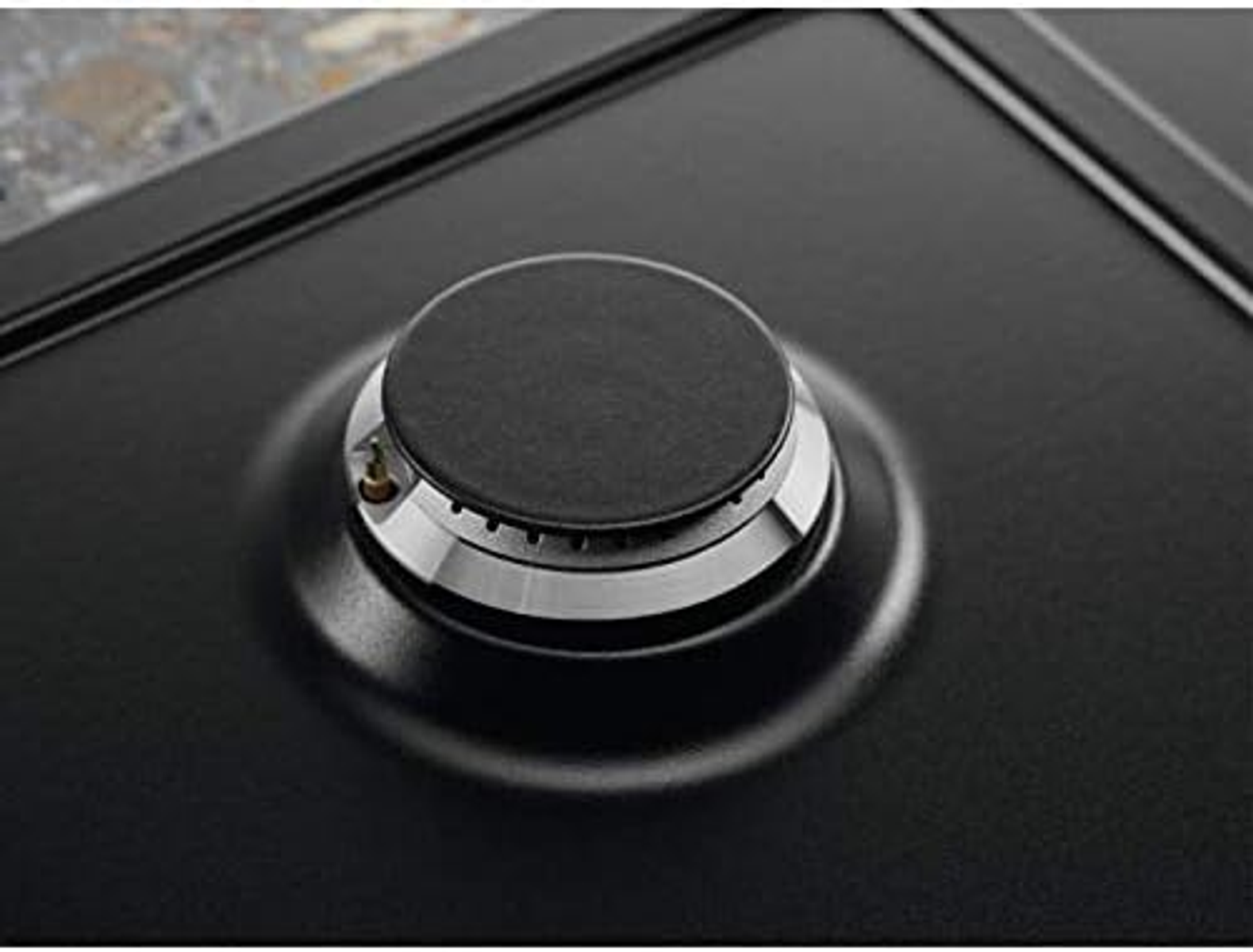 Zbliżenie na czarny palnik płyty grzejnej ze srebrnym pierścieniem.