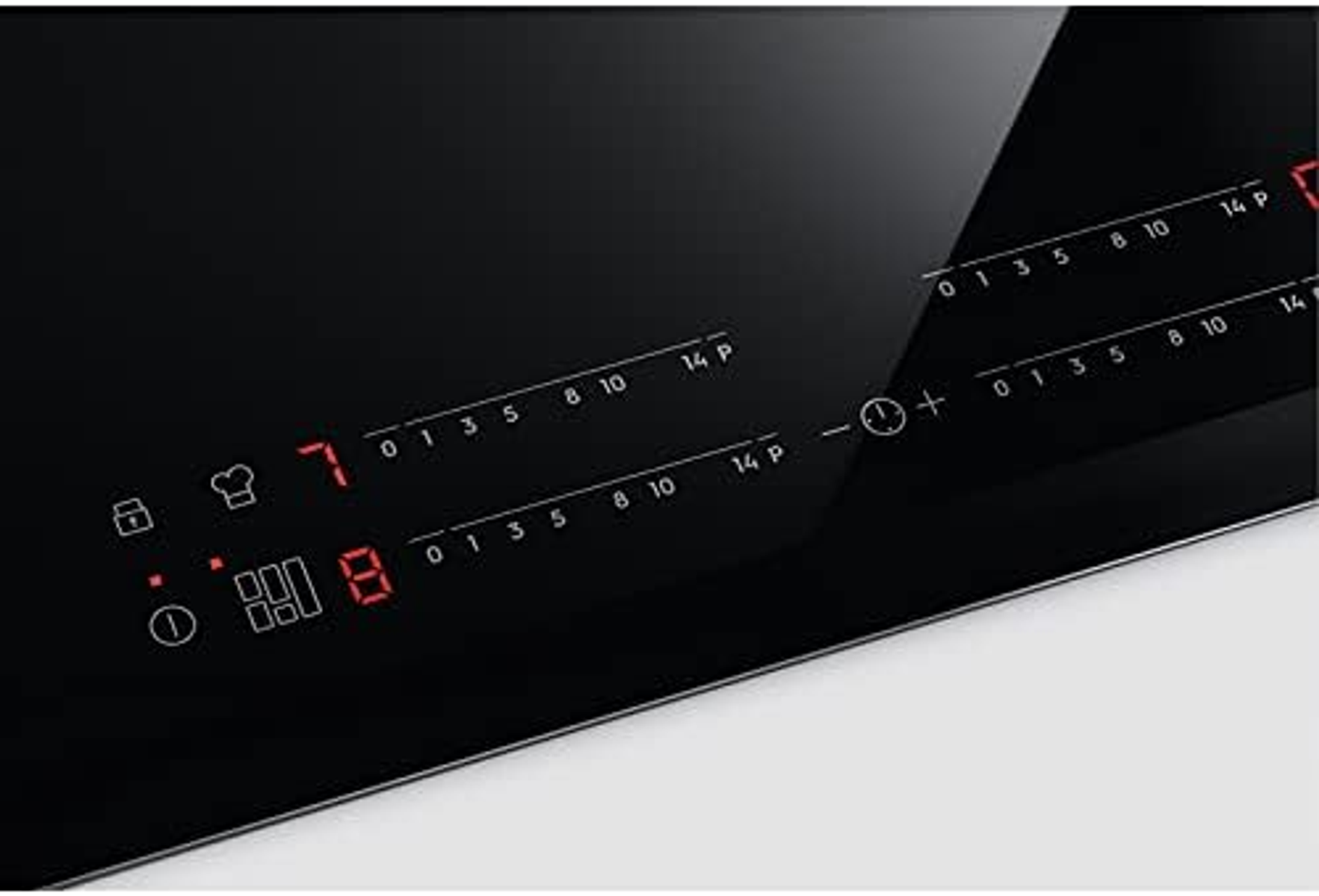 Primer plano del panel de control de una placa de inducción, que muestra números rojos.