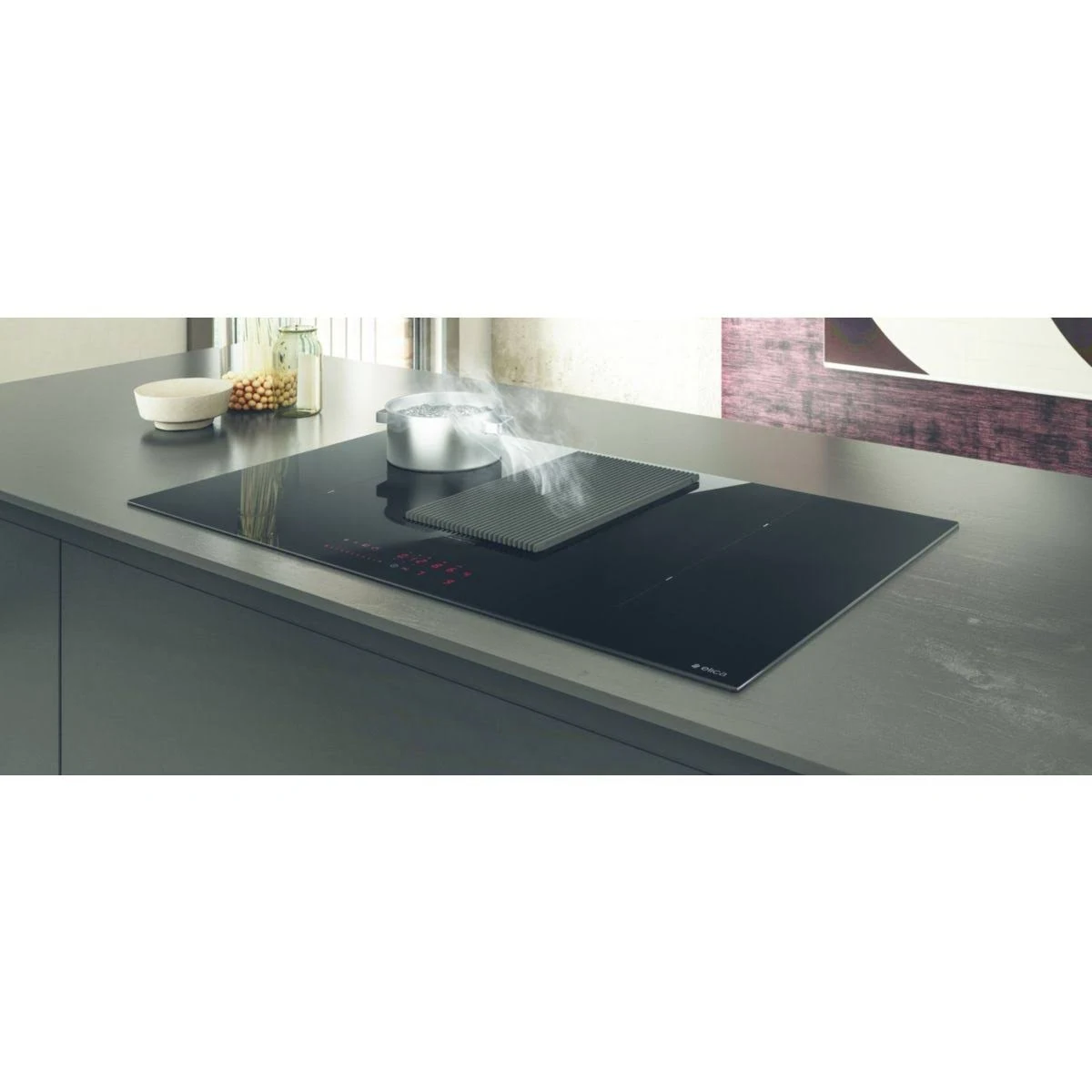 Scena cucina con piano cottura, pentola con vapore e ventola integrata. Su un piano grigio.