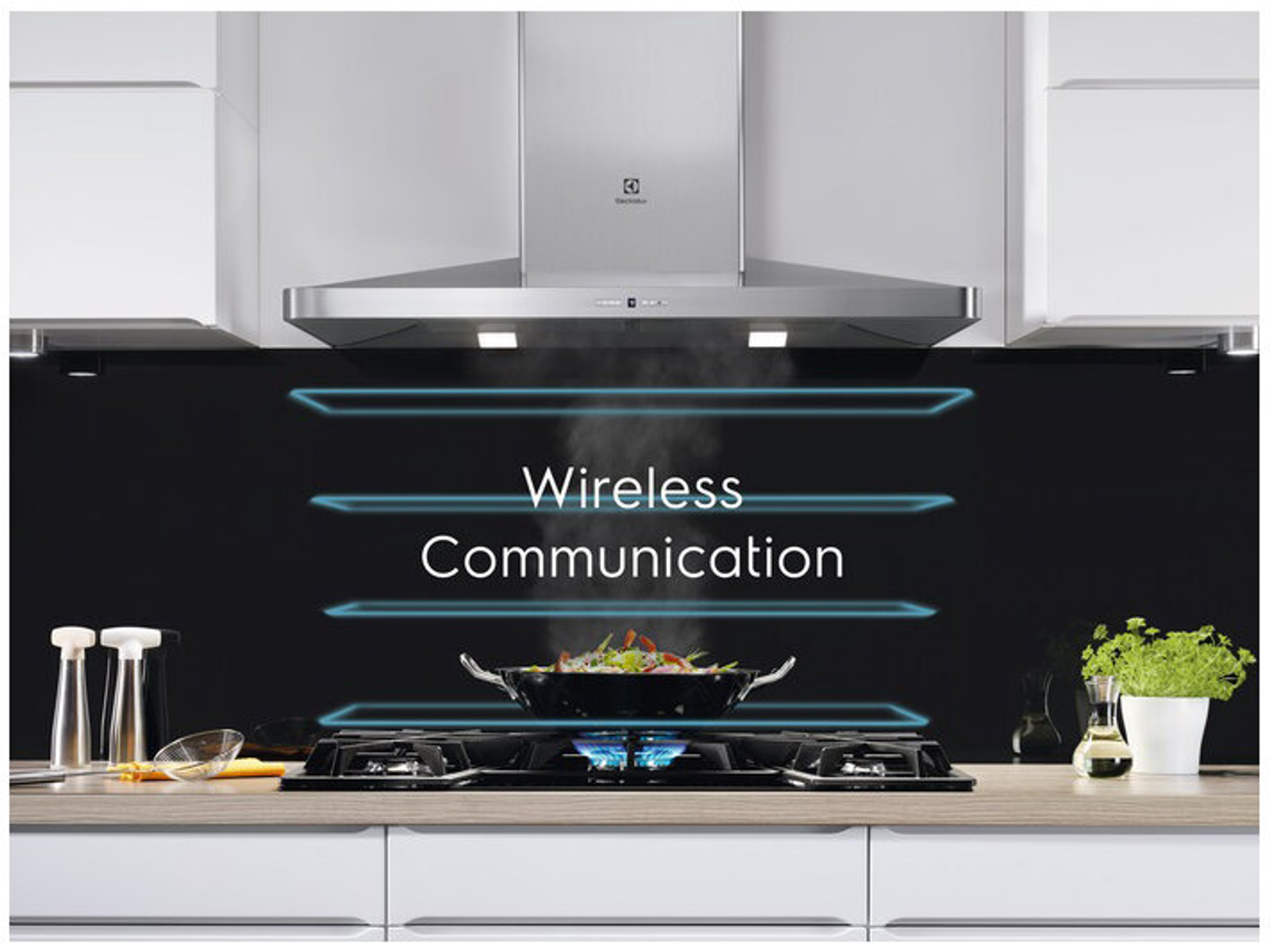 Nowoczesna kuchnia z płytą grzewczą, okapem i tekstem Komunikacja Bezprzewodowa nad parującą patelnią.