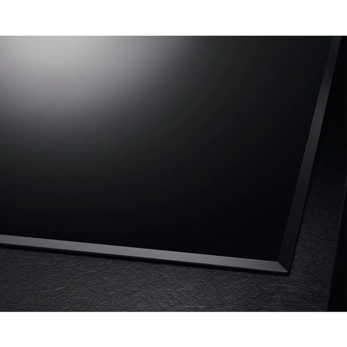 Un primo piano di un piano cottura a induzione nero con un design elegante e moderno.