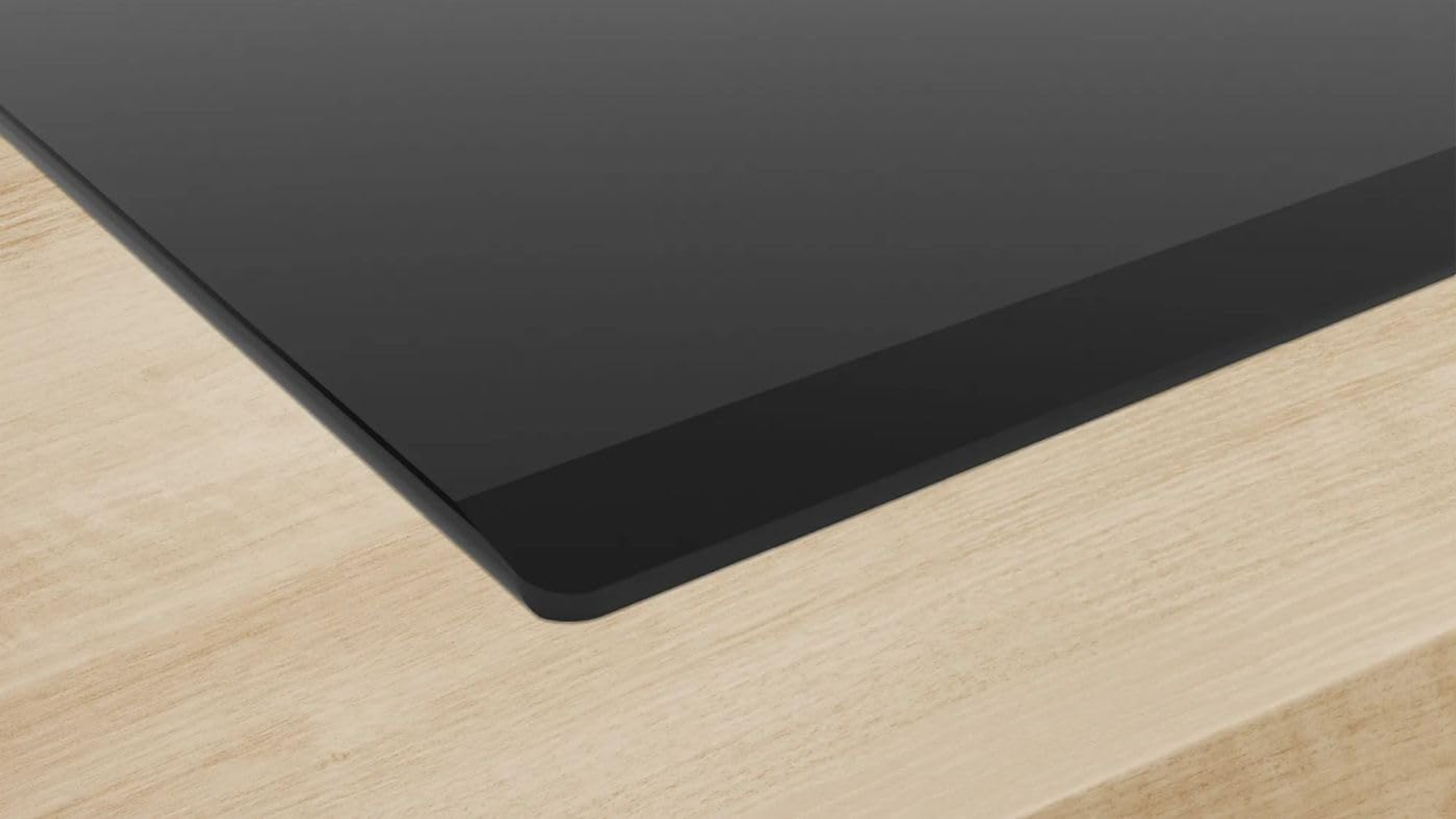 Czarna płyta indukcyjna. Powierzchnia jest błyszcząca i odbija światło.