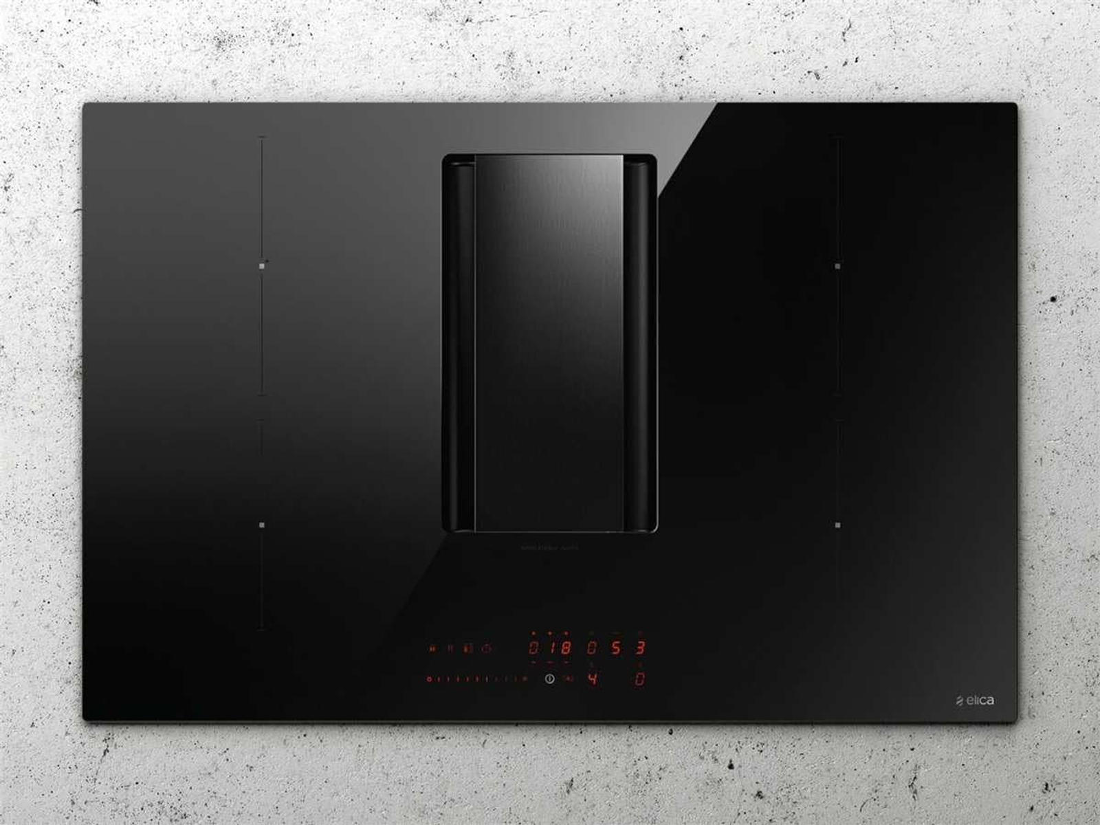 Czarna płyta indukcyjna z centralnym okapem i czerwonym wyświetlaczem cyfrowym na białej powierzchni.