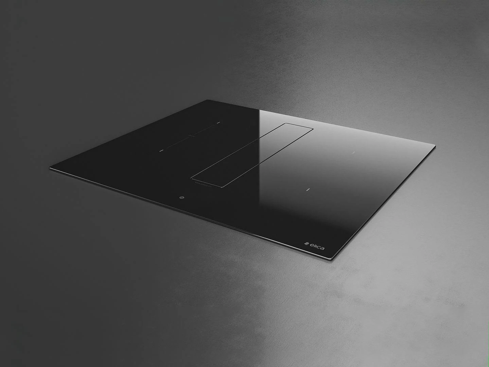 Czarna płyta kuchenna z centralnym wentylatorem, na ciemnoszarym tle, widok z góry.