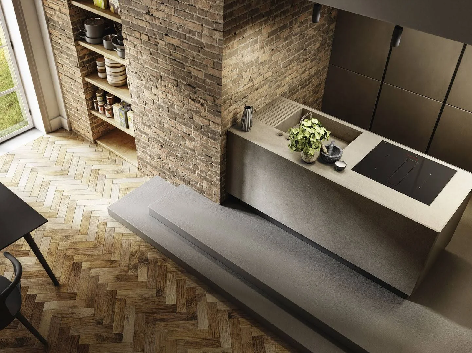 Ujęcie z góry nowoczesnej kuchni z ceglaną ścianą i betonową wyspą.