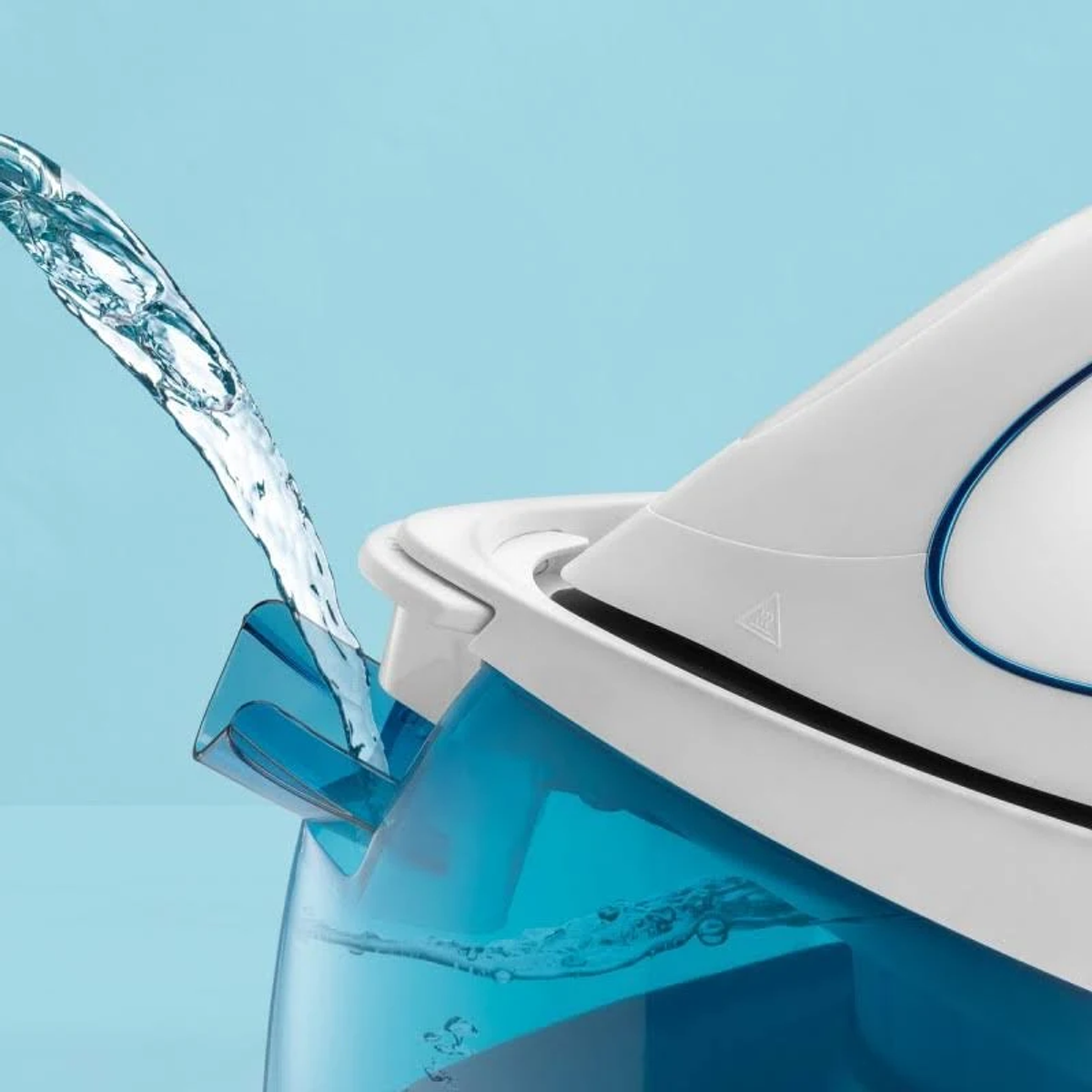 Acqua versata in un ferro da stiro a vapore bianco e blu.
